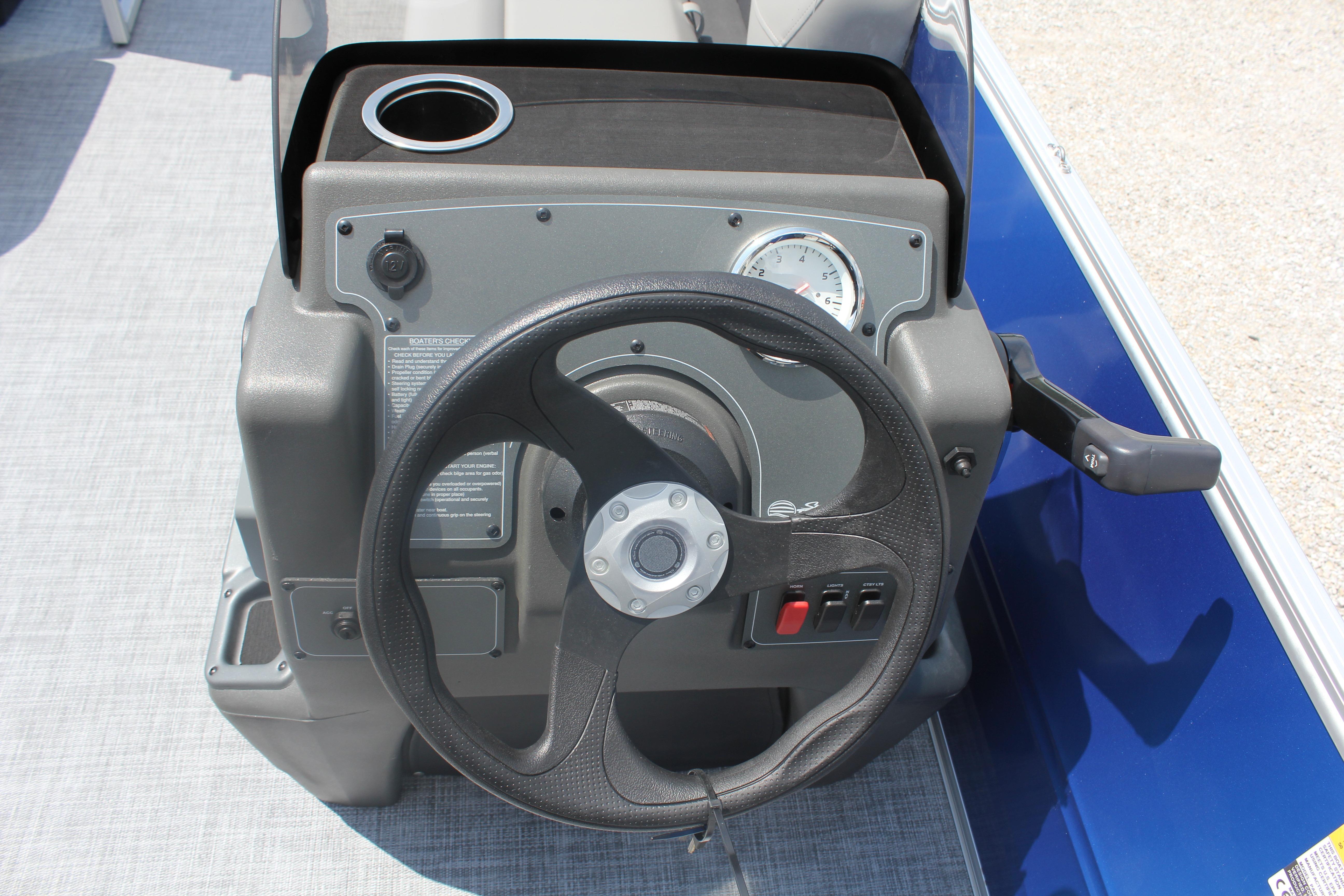 Steering console of 2026 Sun Tracker Party Barge 16 DLX with cup holder and controls.