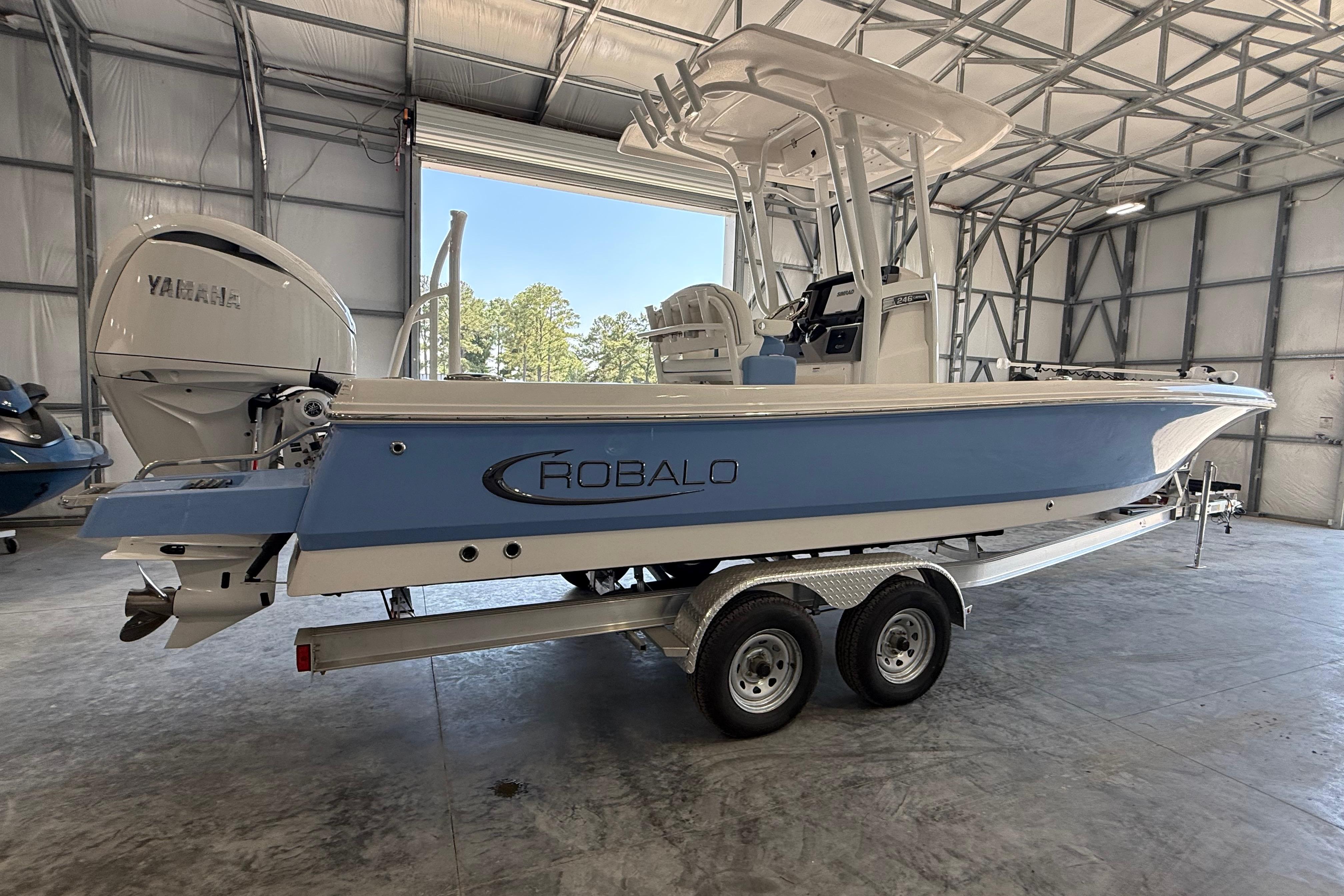 2026 Robalo 246 Cayman boat in a garage, featuring a Yamaha outboard motor.