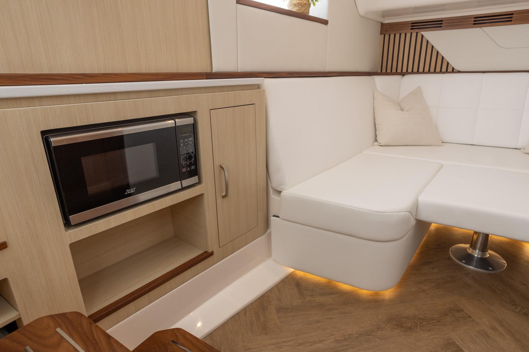 Luxurious interior of 2026 Regal LX43 yacht with modern kitchenette and cozy seating.