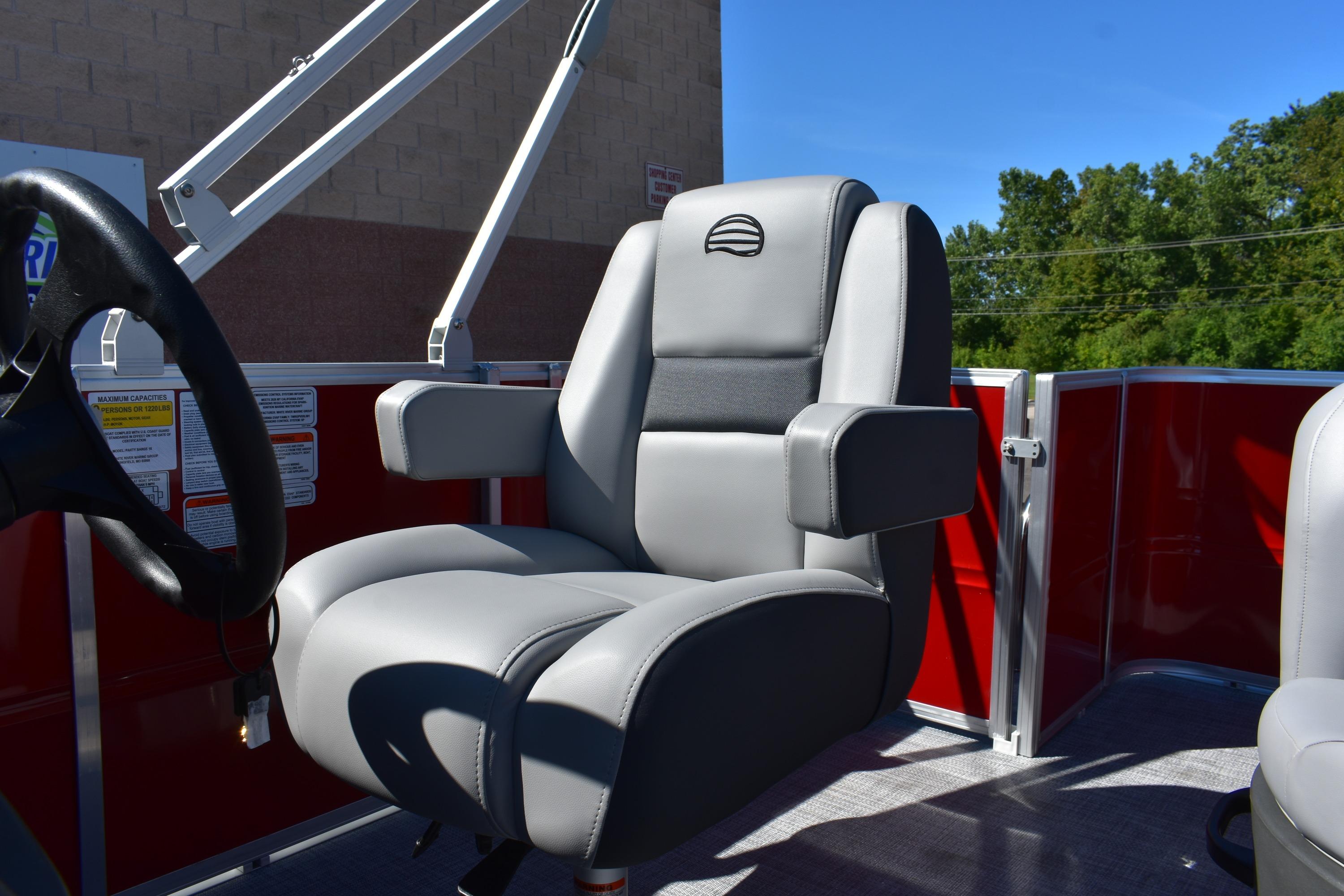 2026 Sun Tracker Party Barge 18 DLX captain's chair with armrests and steering wheel.