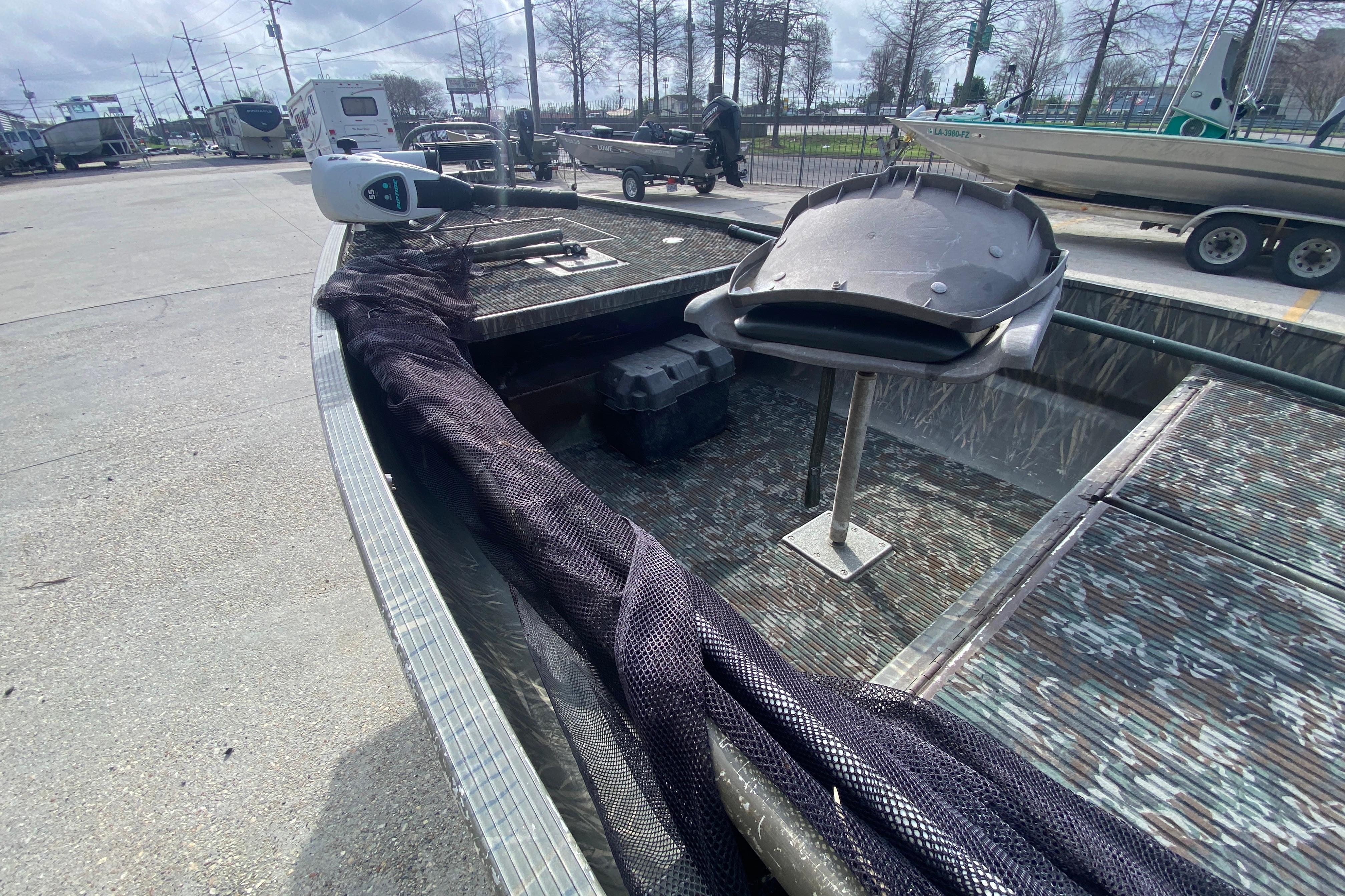 2009 Gator Trax MUD BUDDY boat with camo interior, parked outdoors.
