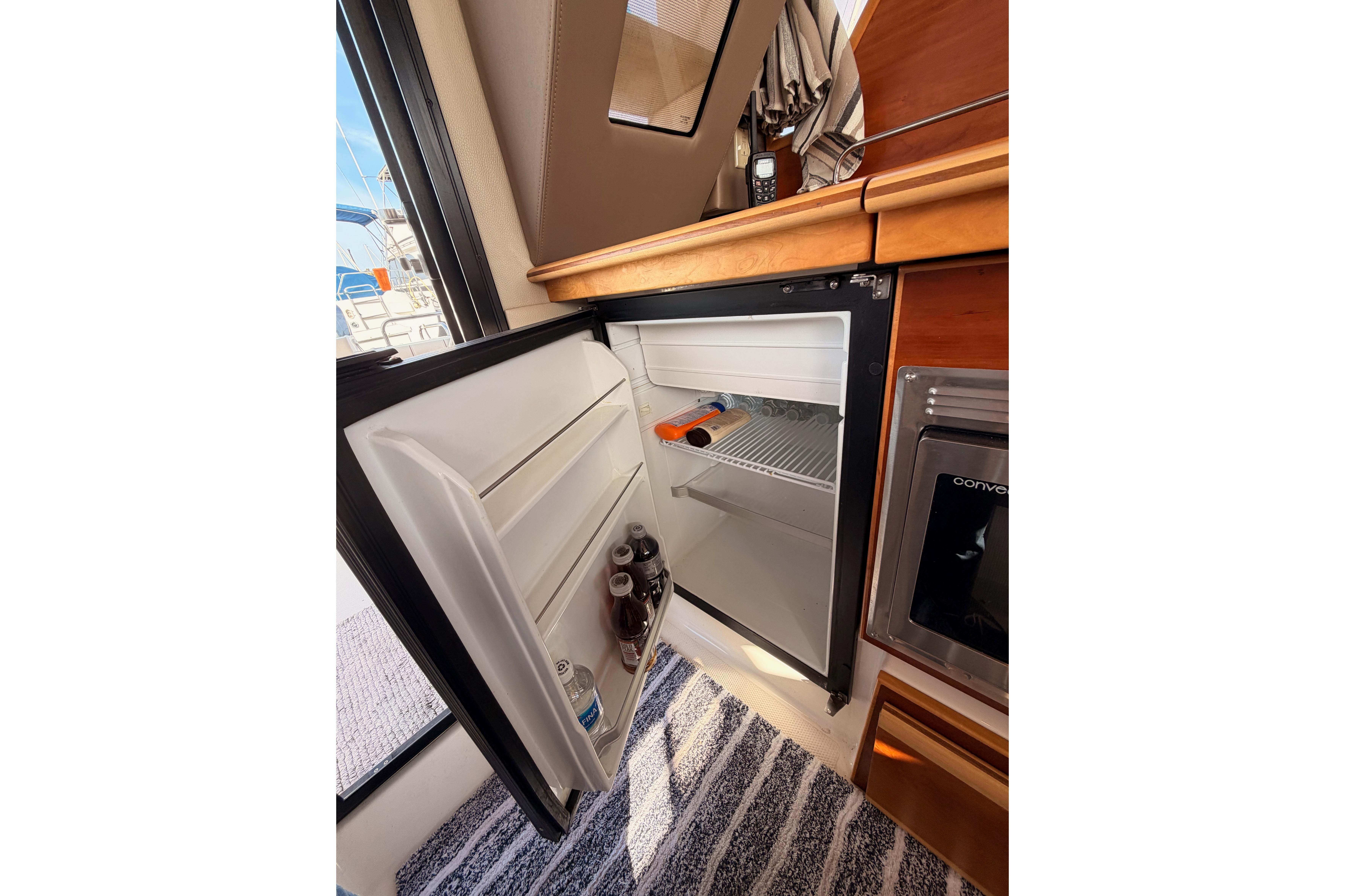 2021 Cutwater C-32 CB yacht interior with open mini fridge and beverages.
