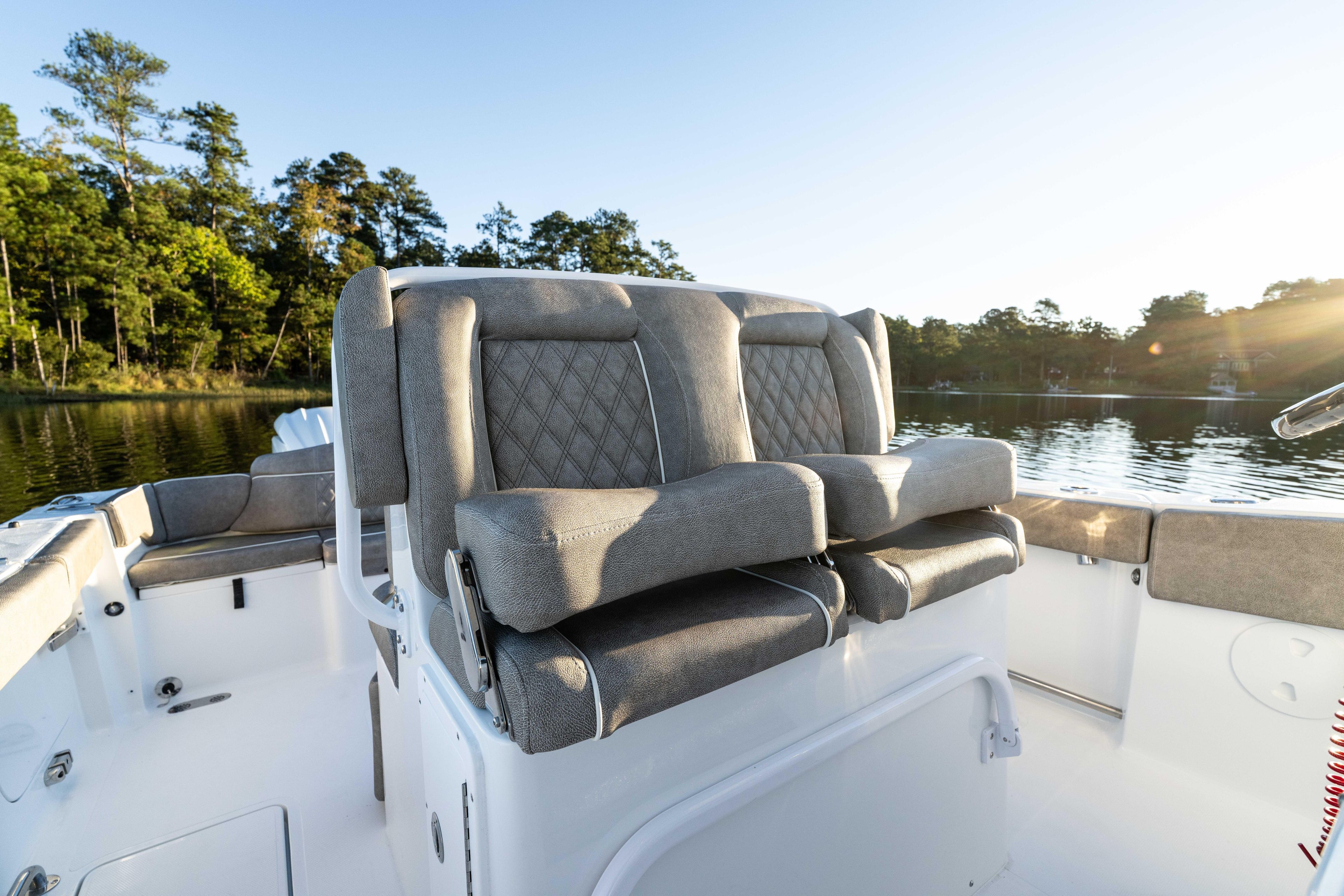 2026 Sea Hunt Ultra 275 Coffin Box boat interior with cushioned seating on a serene lake.
