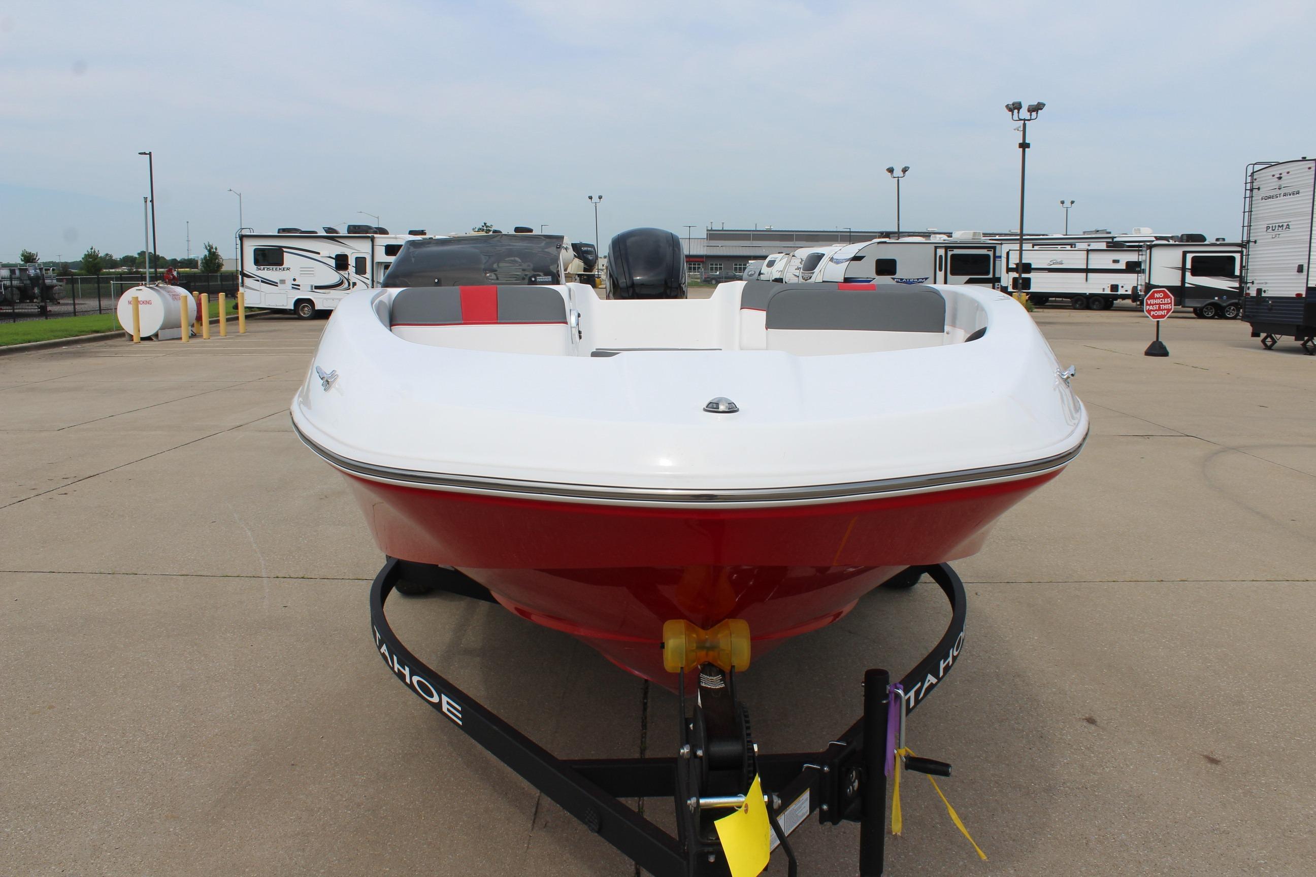 2026 Tahoe T16 boat in parking lot, front view with trailers in background.