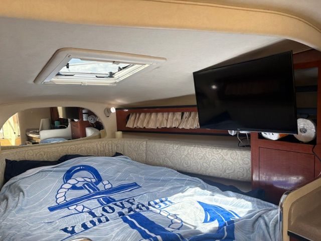 Interior of a Sea Ray Sundancer 280 with bed and TV.