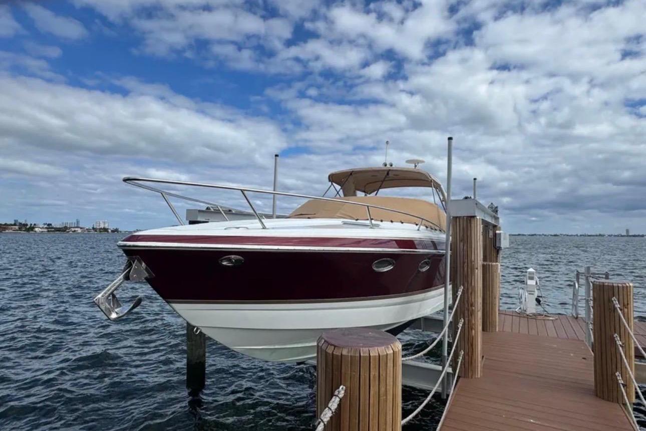 2010 Formula 310 Sun Sport boat docked on a sunny day with cloudy sky.