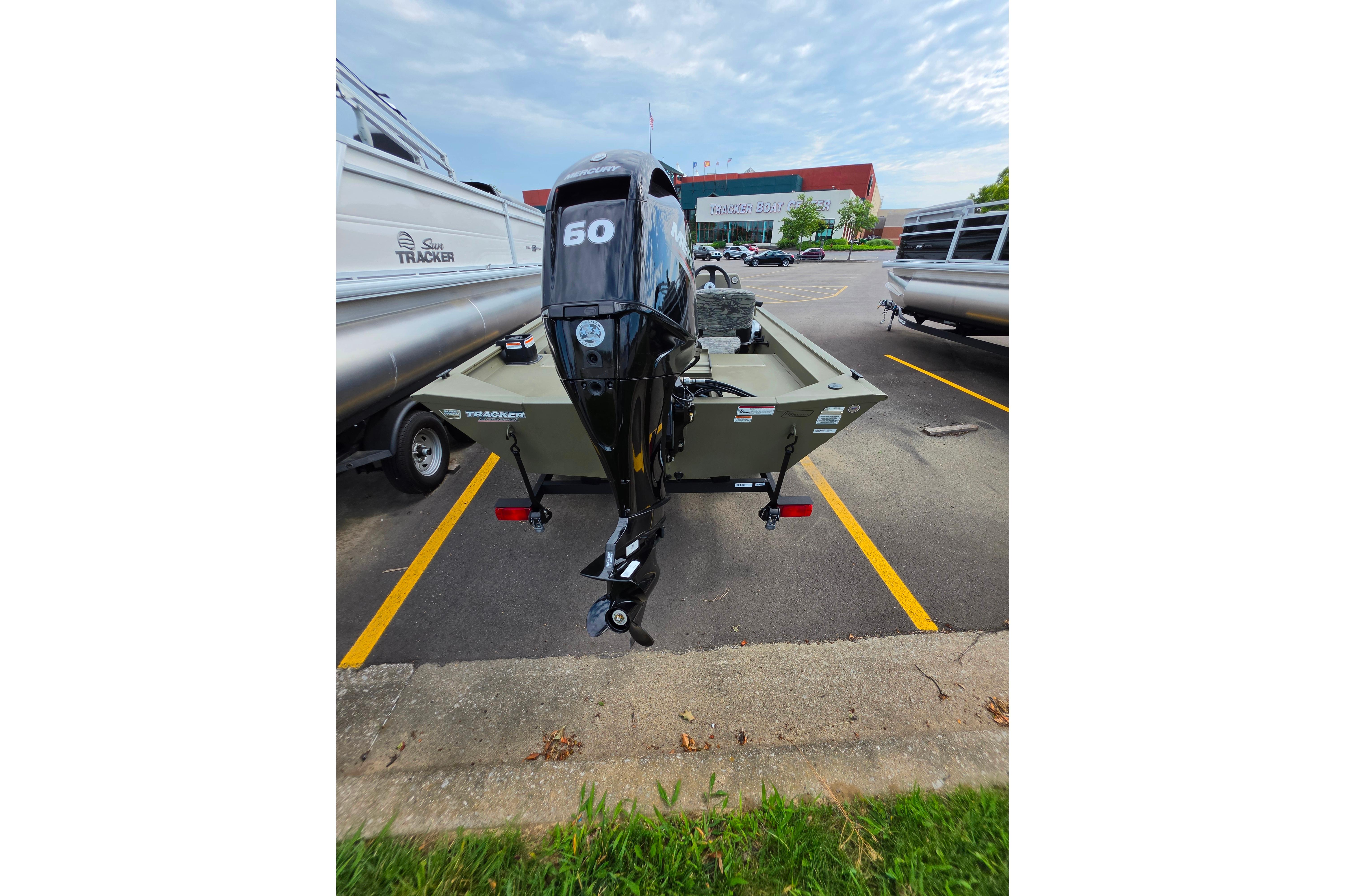 2026 Tracker Grizzly 1754 SC boat with 60 HP motor in parking lot.