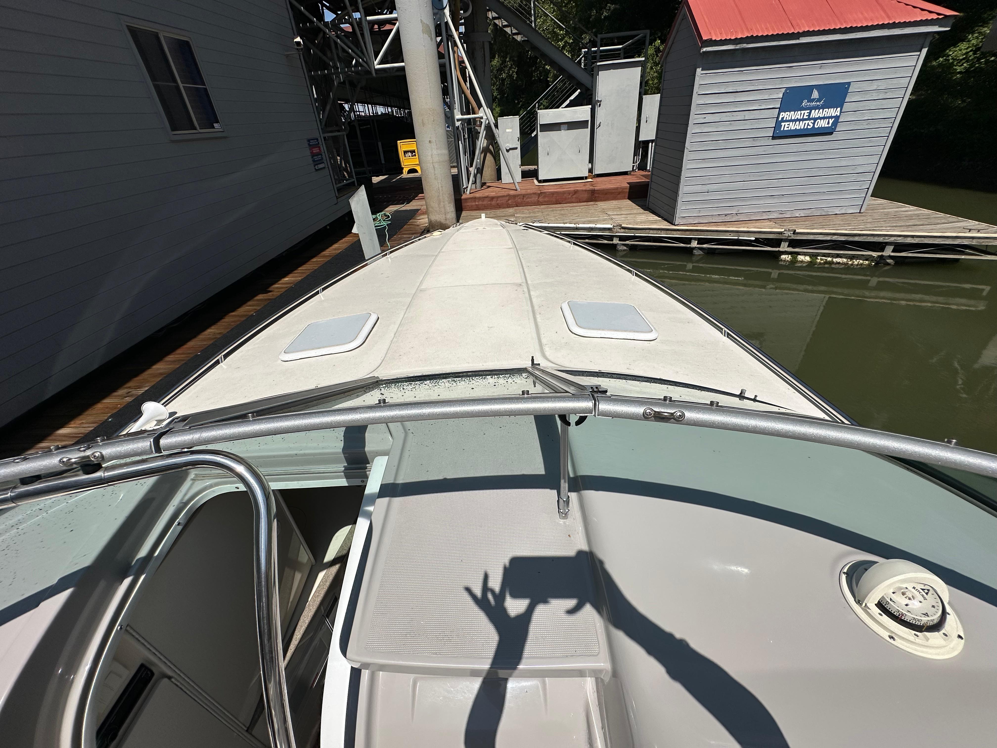 2000 Formula 330 SS boat docked near a marina building.