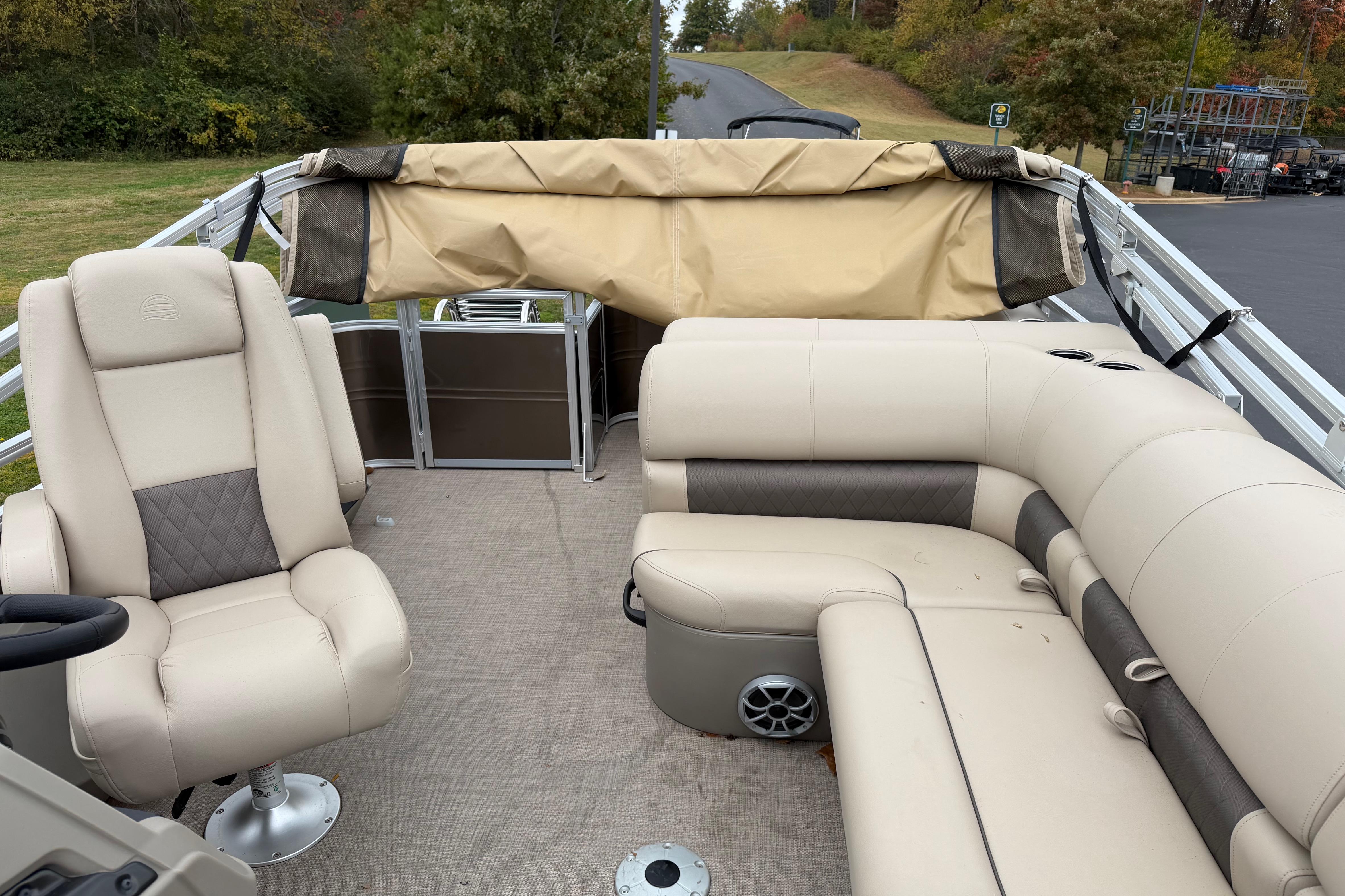 2025 Sun Tracker Sportfish 24 XP3 pontoon boat interior with beige seating and helm.