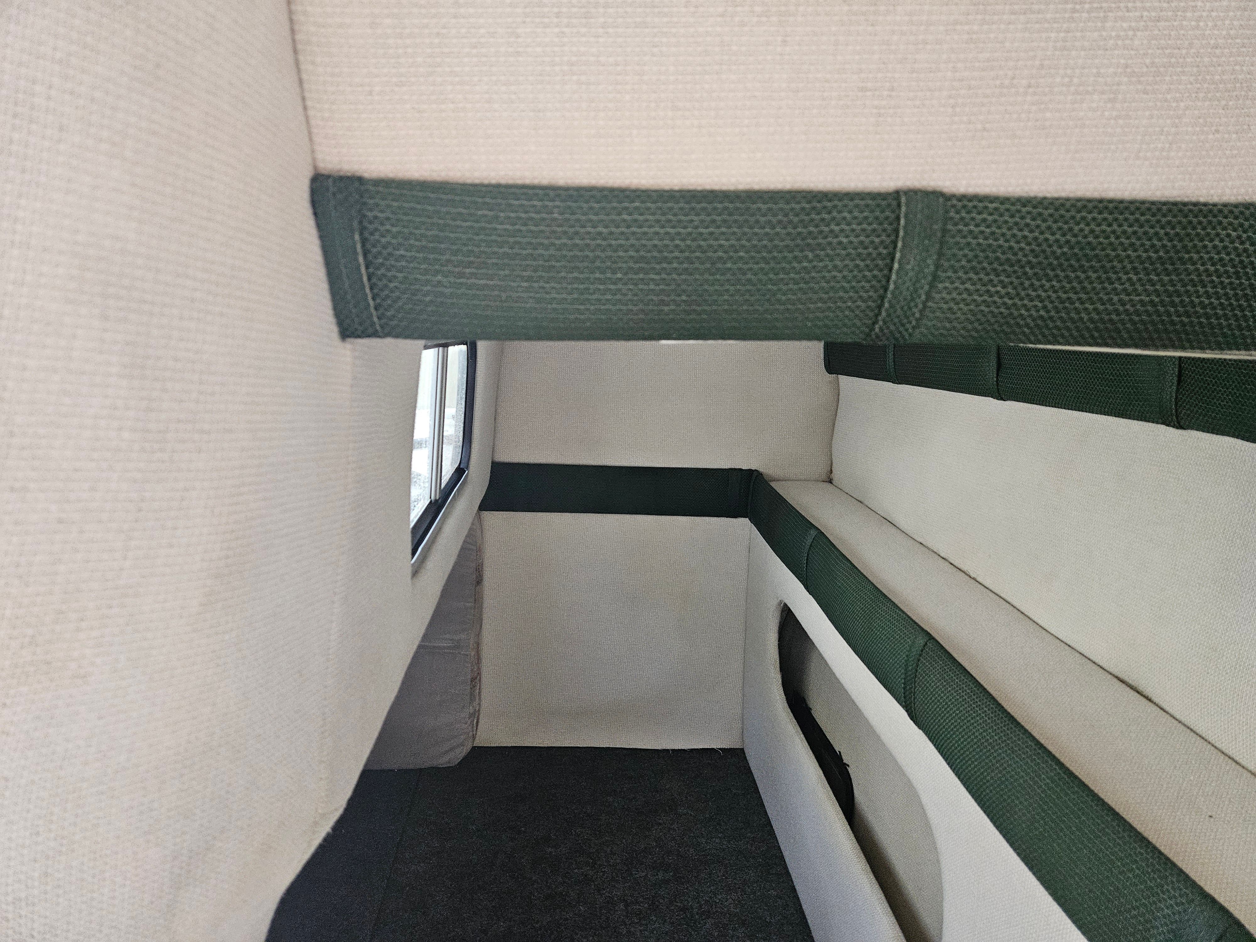Interior of a 1998 Larson Cabrio 254 boat with green upholstery.