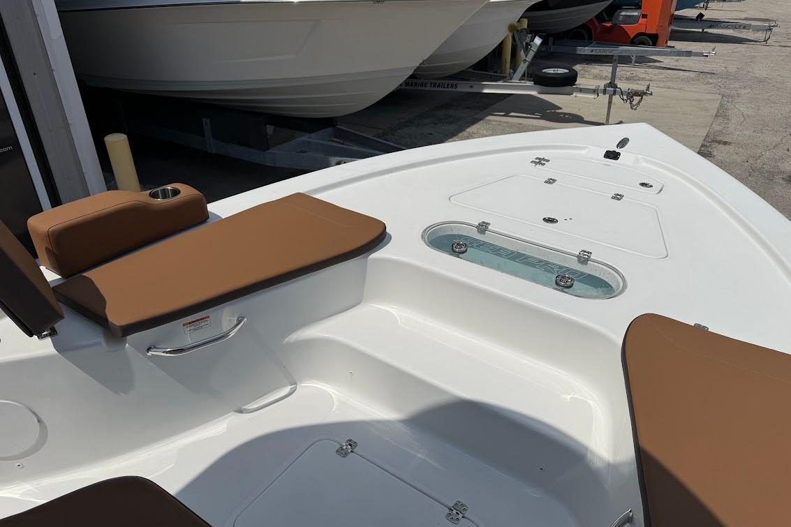 2026 Sea Pro 250 Bay boat interior with brown seating and storage compartments.