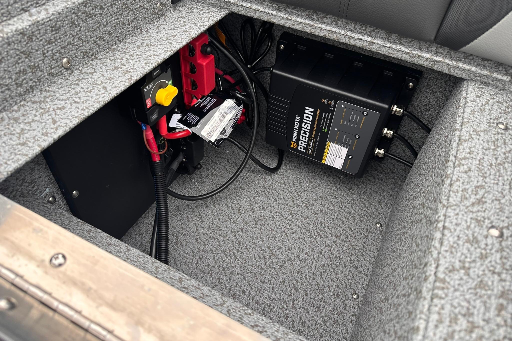 2026 Lund 1775 Impact XS Sport boat battery compartment with Minn Kota Precision charger.