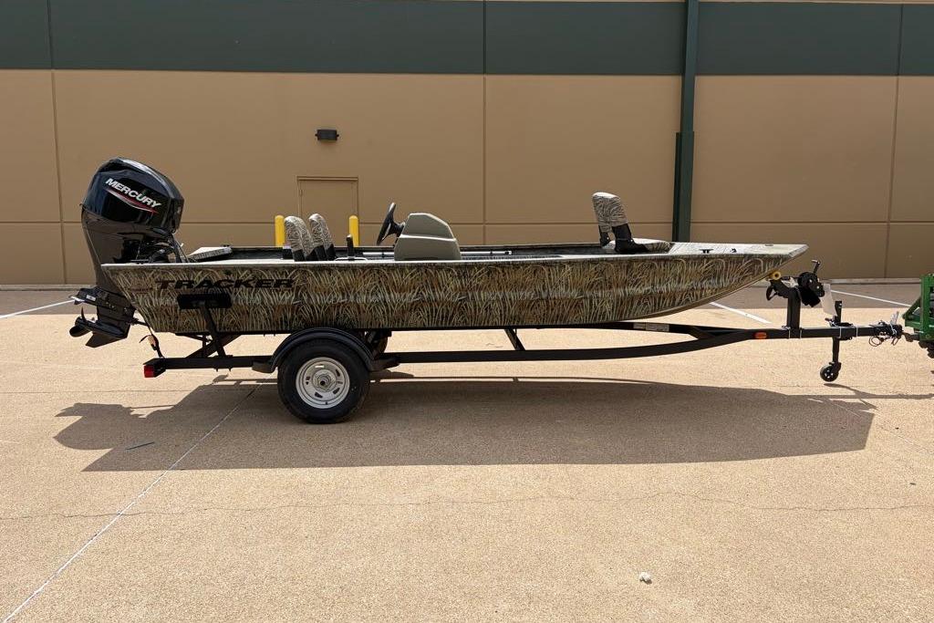 2026 Tracker Grizzly 1754 SC boat on trailer, camo design, parked outdoors.