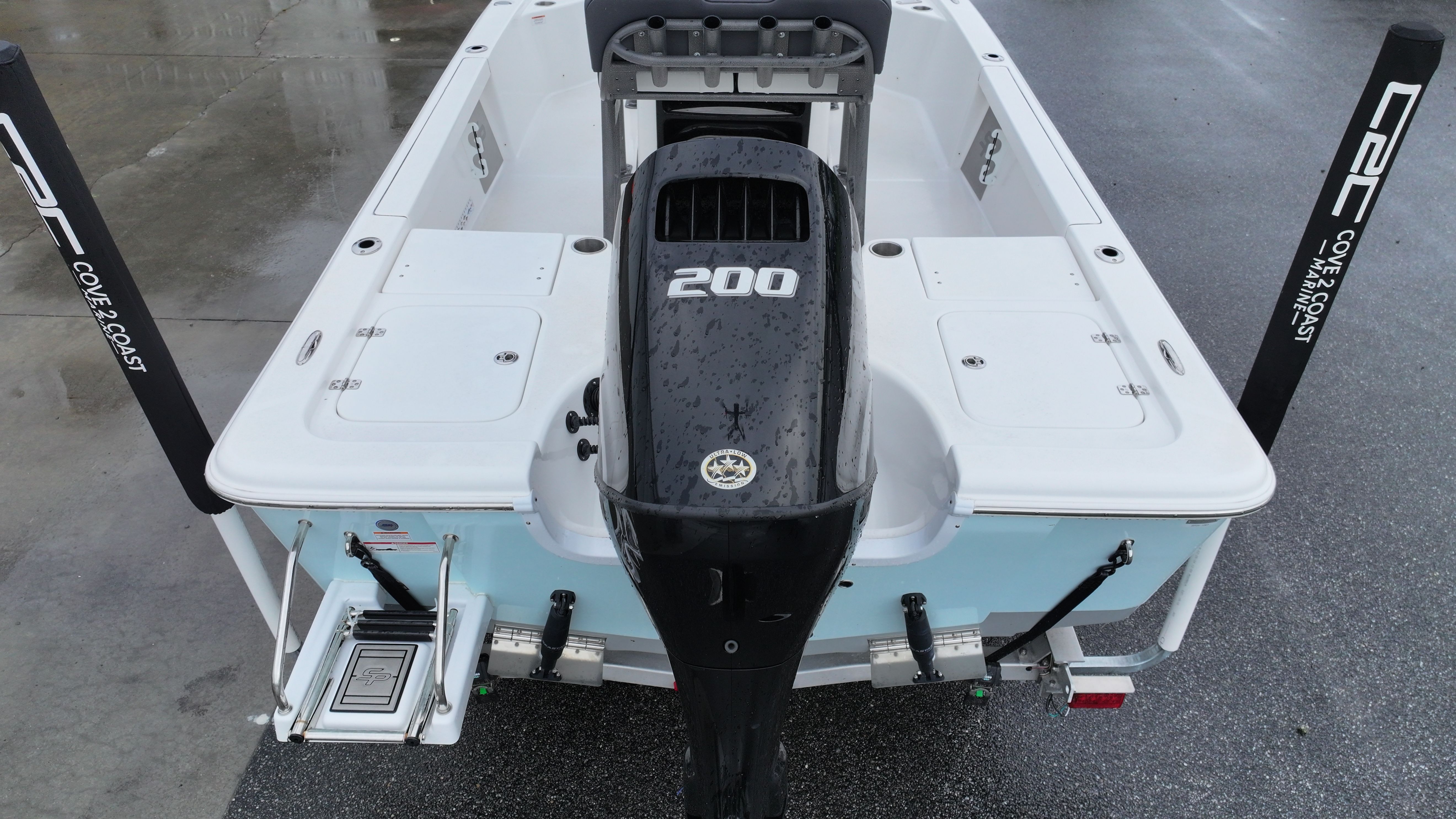 Rear view of a Sea Pro 230 DLX with a 200 HP outboard motor, on a wet dock.