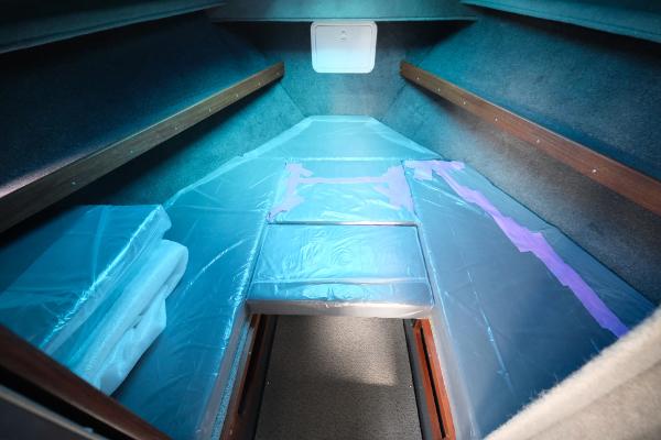 Interior cabin of 2024 Hewescraft 250 Explorer boat, featuring cushioned seating and storage.