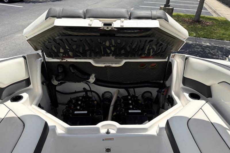 2017 Yamaha Boats SX210 engine compartment with open hatch, showcasing dual engines and seating area.