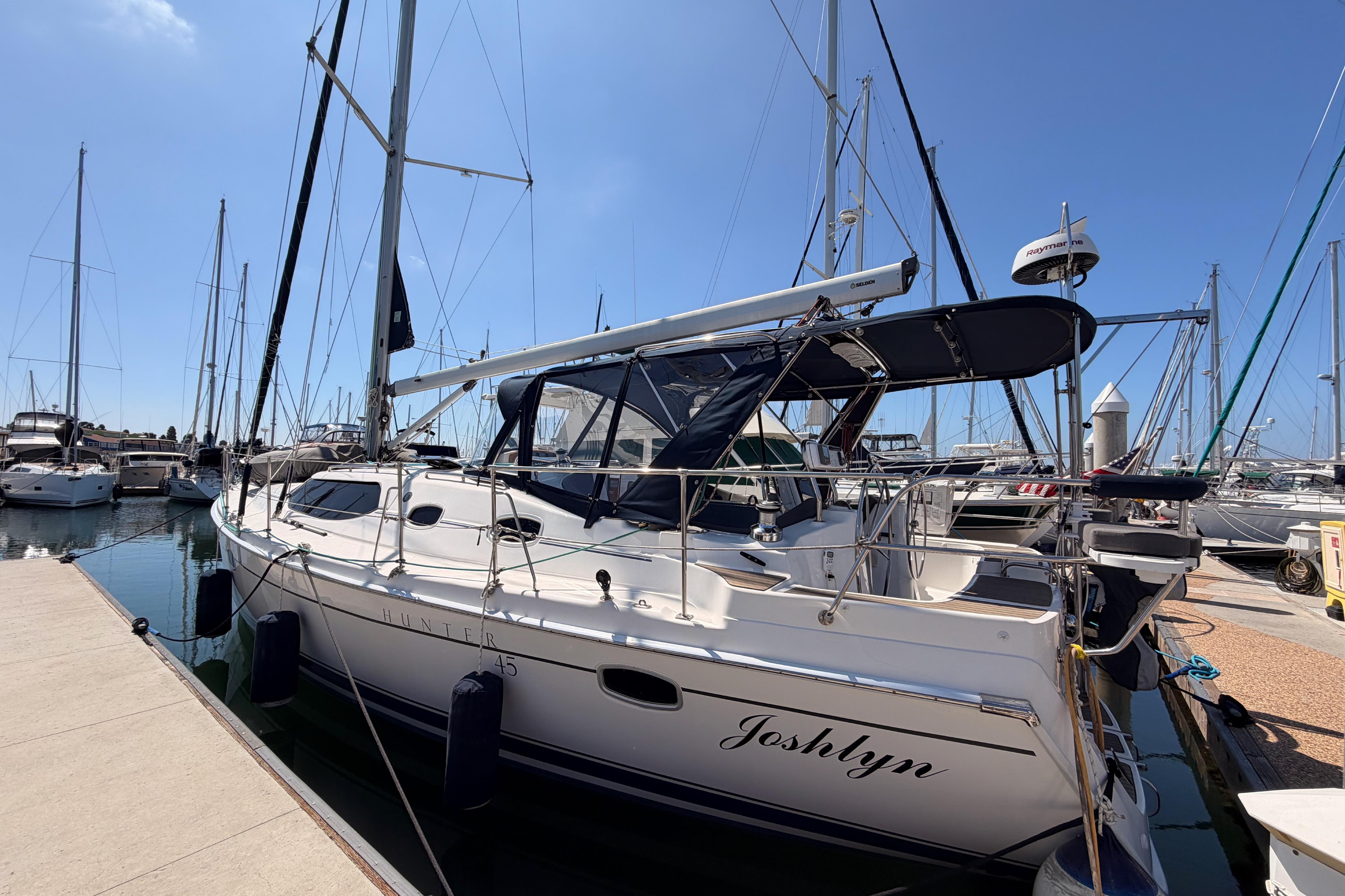 2008 Hunter 45 Deck Salon sailboat docked at marina under clear blue sky.