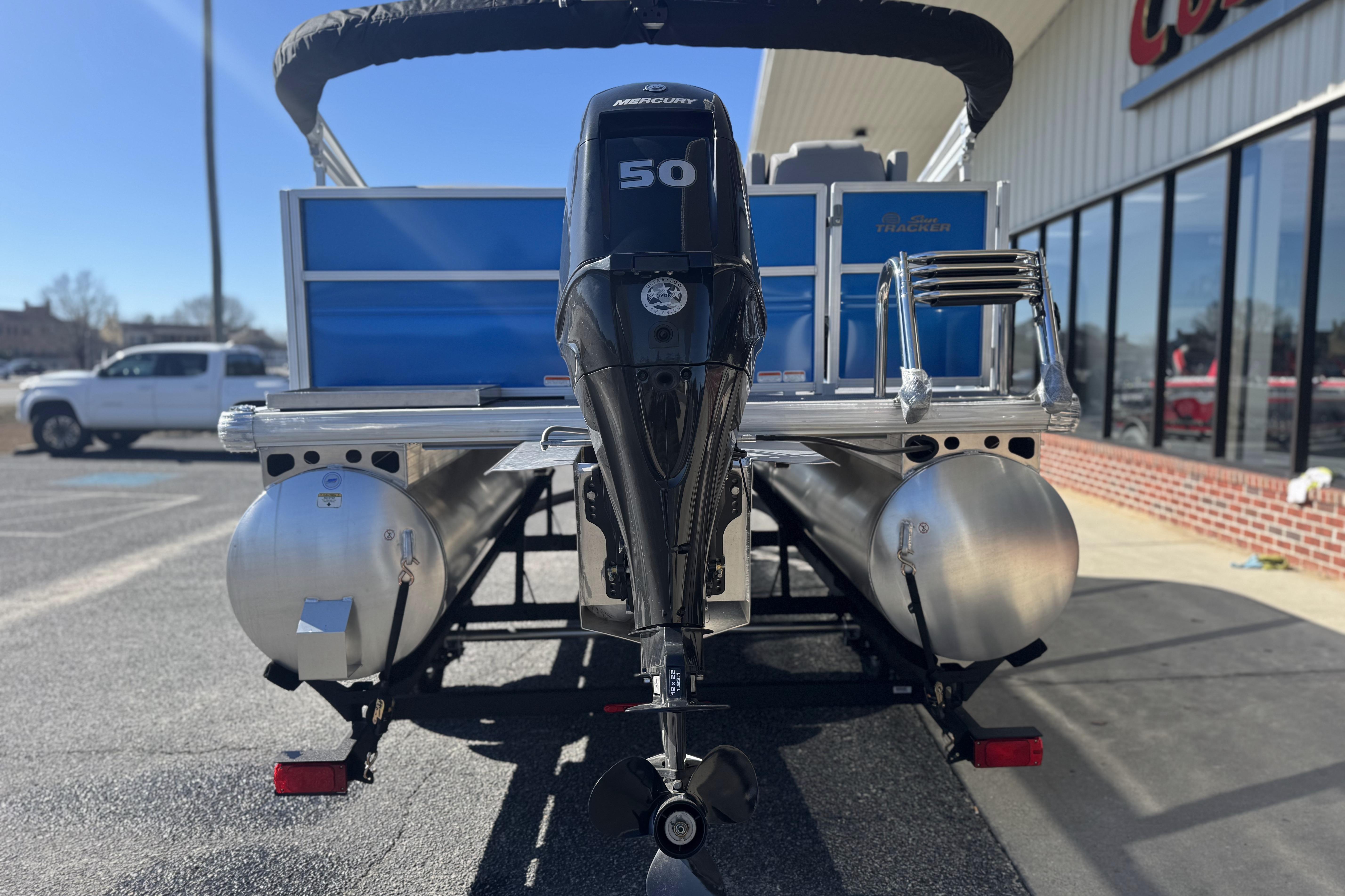 2026 Sun Tracker Party Barge 16 DLX pontoon boat with Mercury 50 engine, parked outdoors.