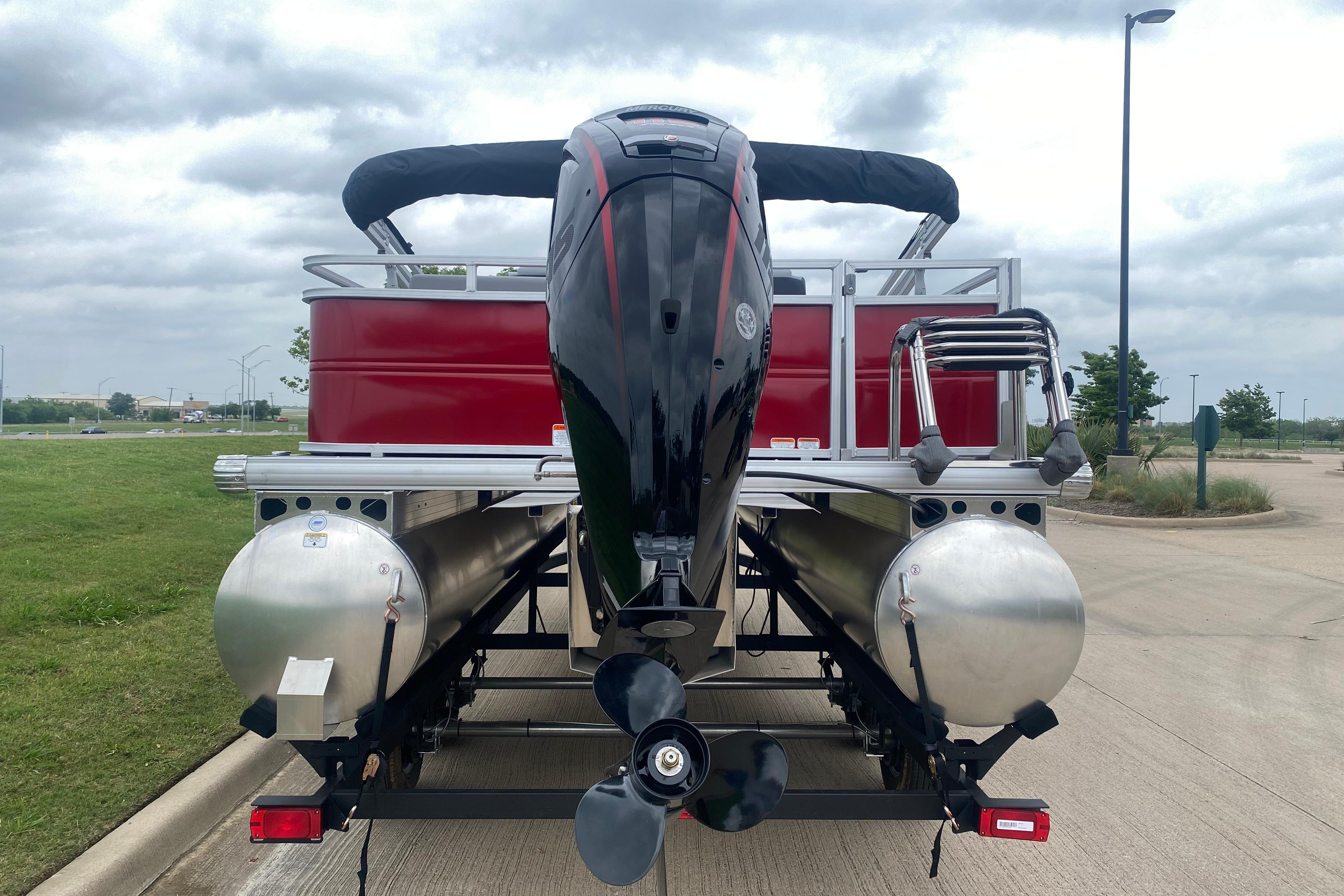 2026 Sun Tracker Party Barge 22 RF DLX pontoon boat, rear view with motor and ladder.