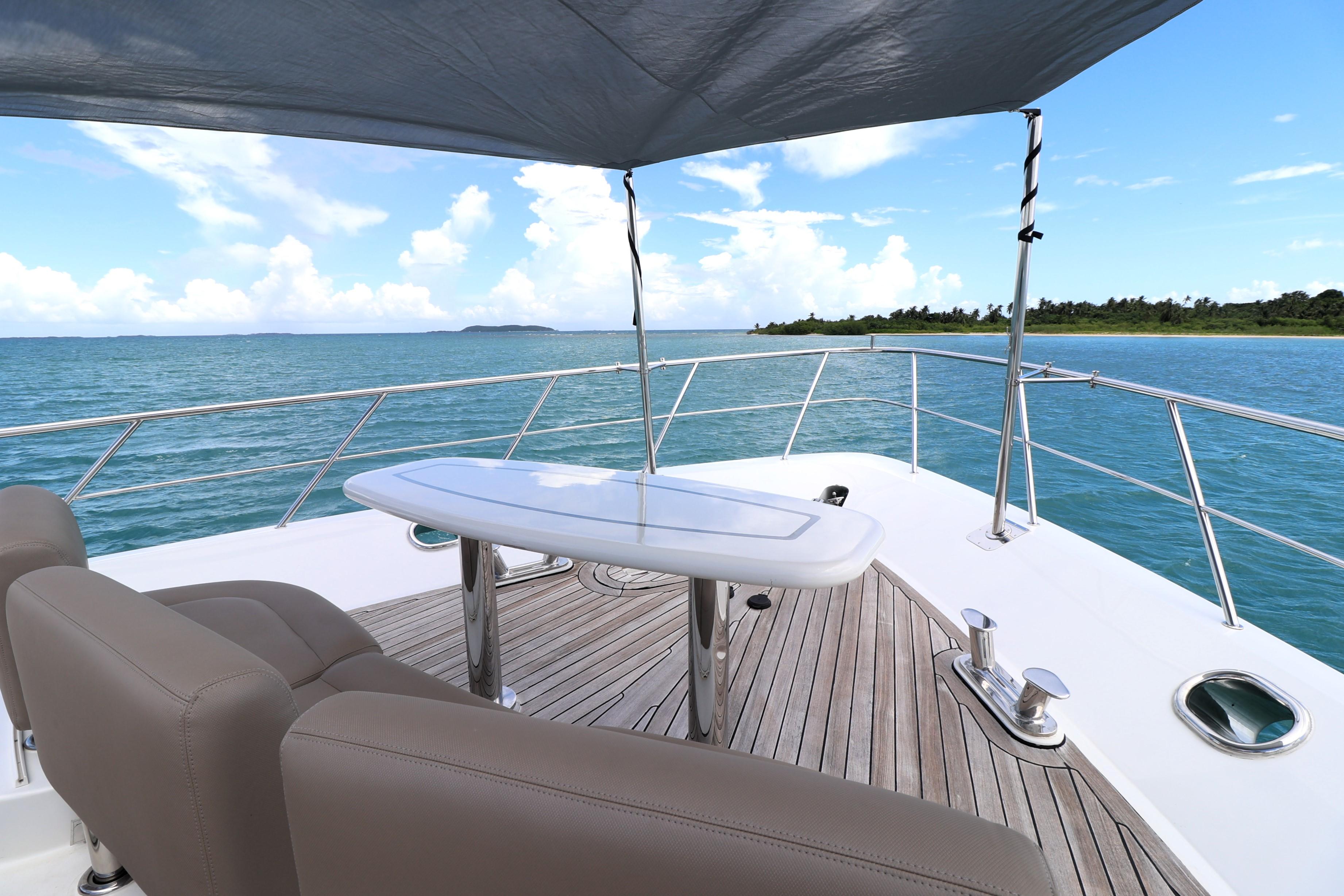 Luxury deck of 2013 Cheoy Lee Bravo yacht with ocean view and seating area.
