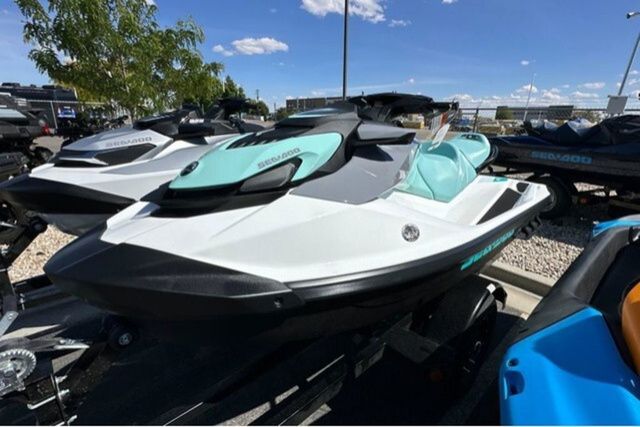 A Sea-Doo jet ski, model GTI 130 WH IBR 26 STD, is parked outdoors.