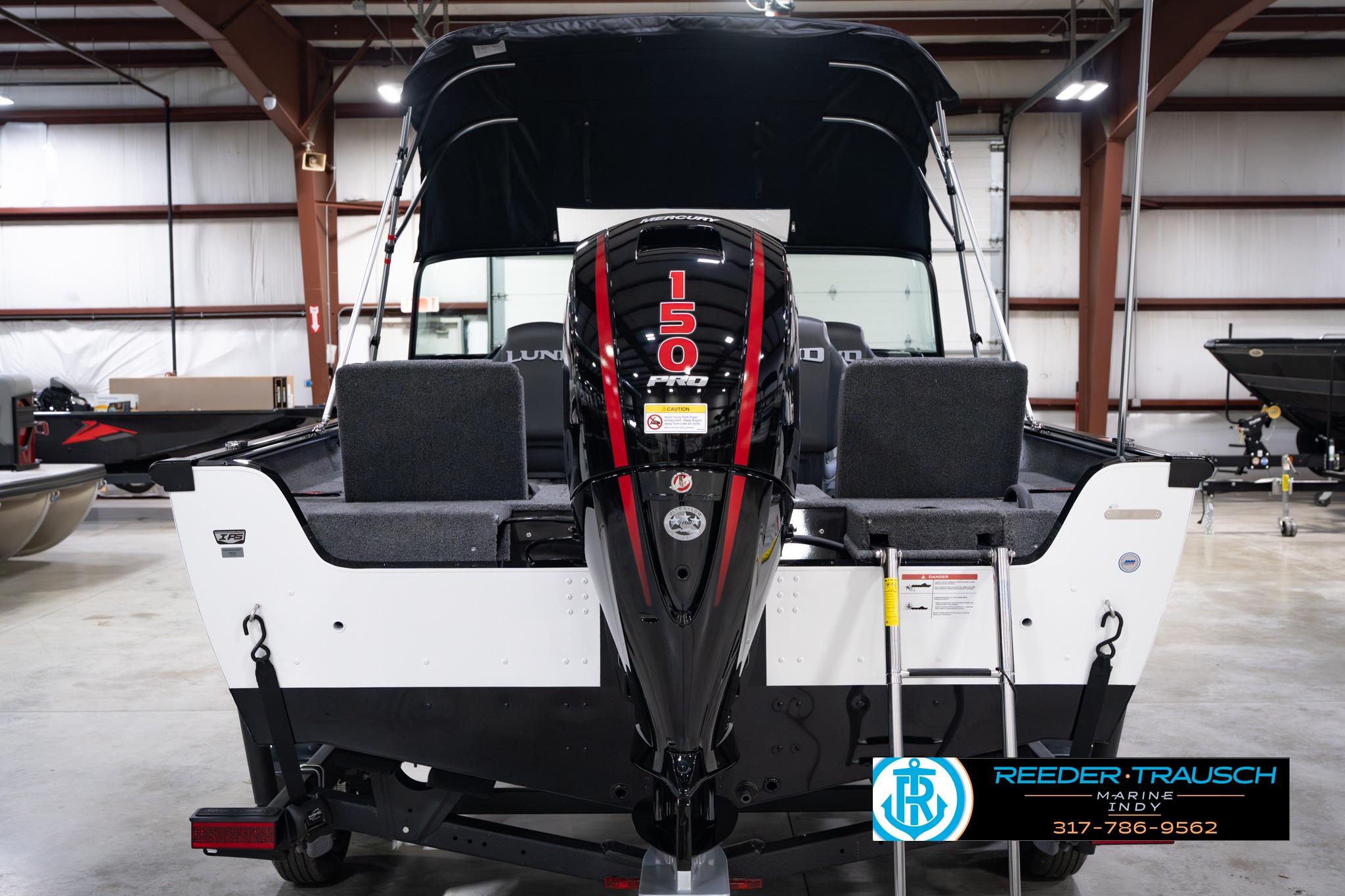 2026 Lund 1875 Impact XS SS boat with 150 HP engine in showroom.