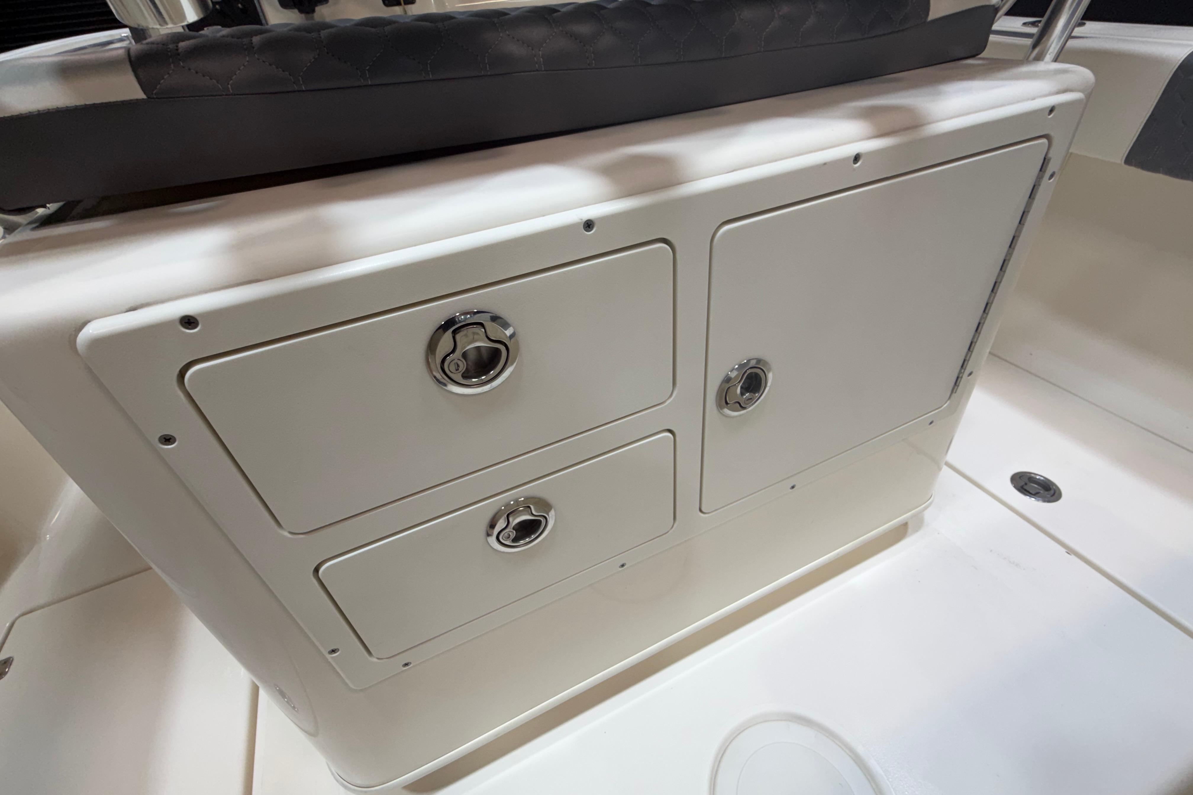 2023 Cobia 237 Center Console storage compartments with secure latches and sleek design.