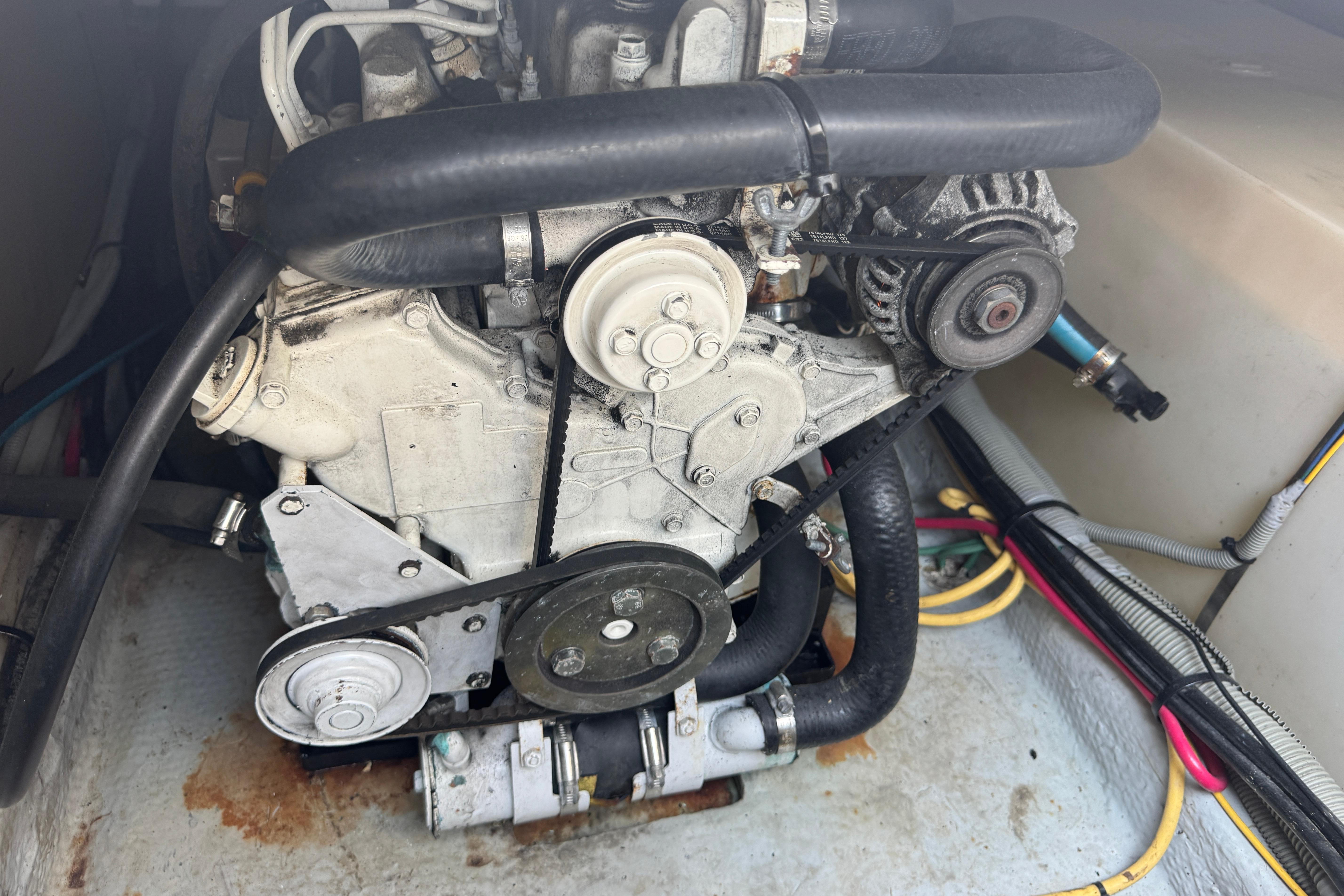 Engine compartment of a 2002 Mainship 390 Trawler with visible belts and hoses.
