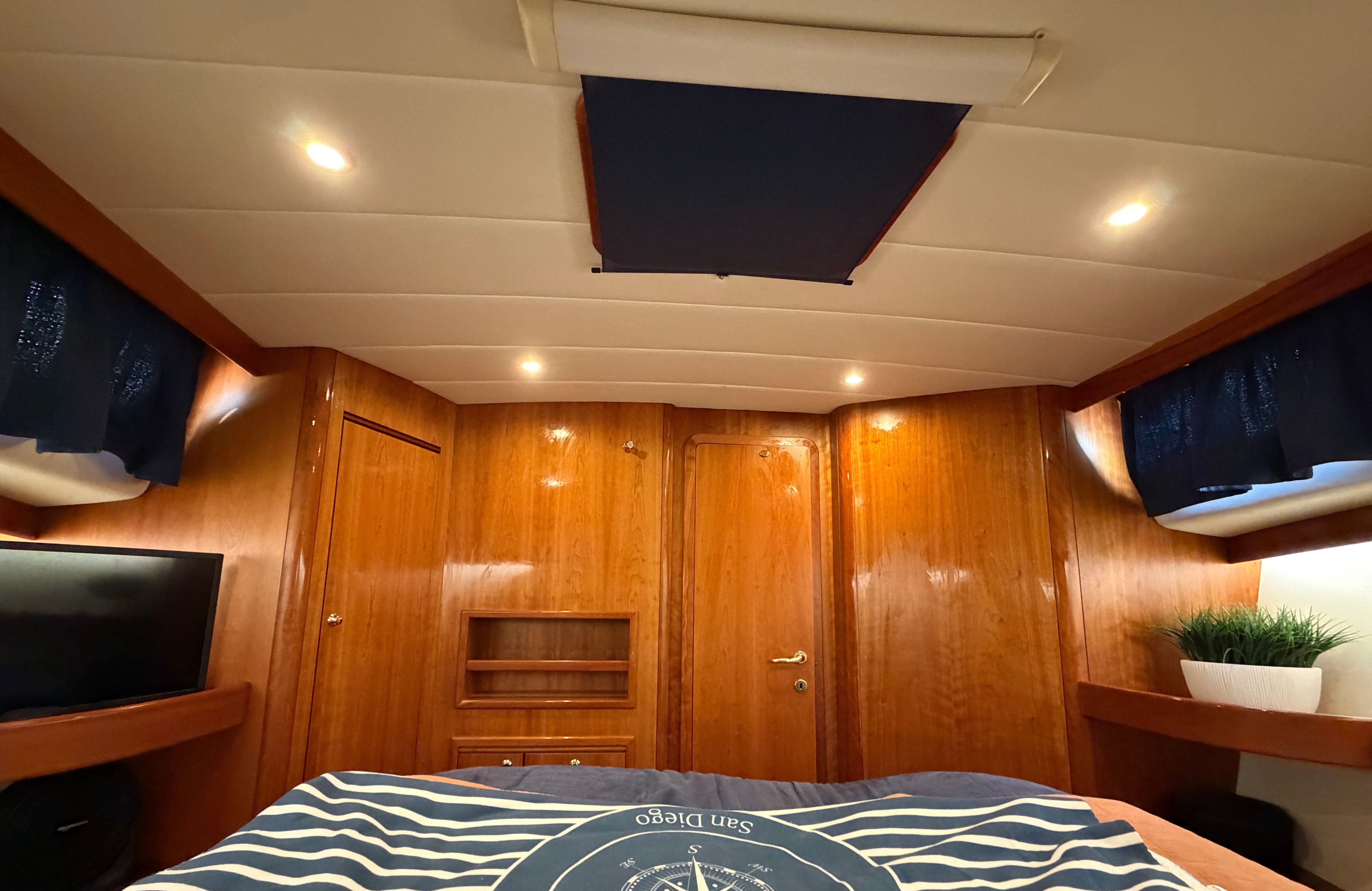 Interior of a 2003 Apreamare 11 with wooden walls and a bed.