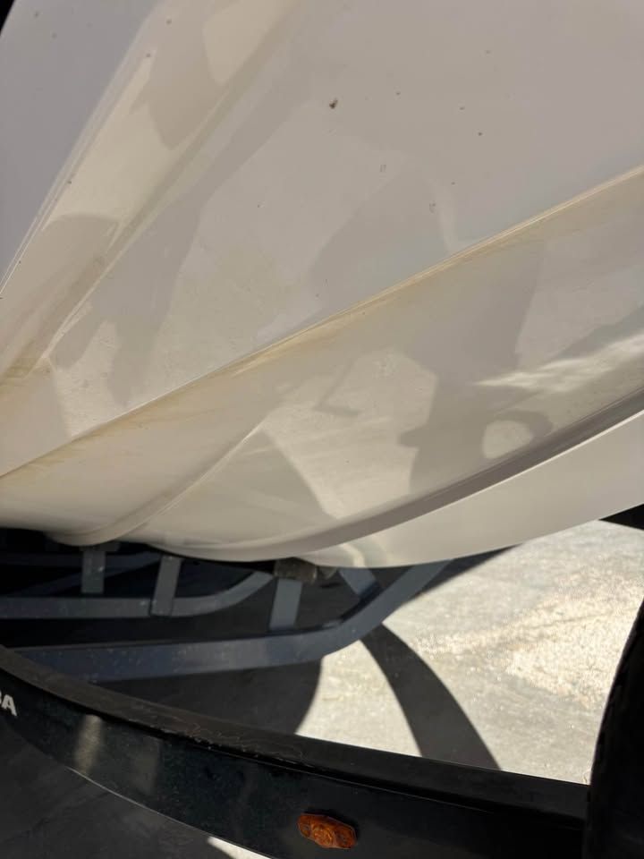 Close-up of a white hull of a 2015 Moomba Mojo boat on a trailer.