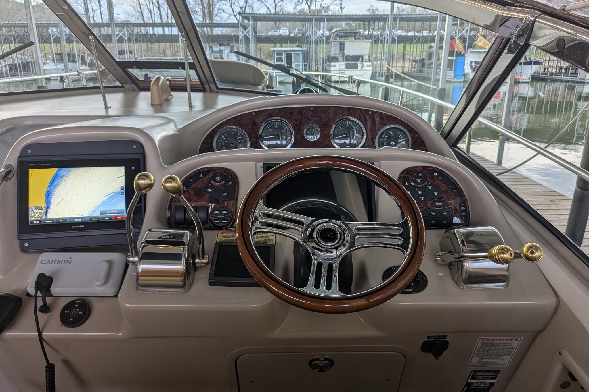 Cockpit of 2002 Sea Ray Sundancer 320 with Garmin navigation system and classic wood steering wheel.
