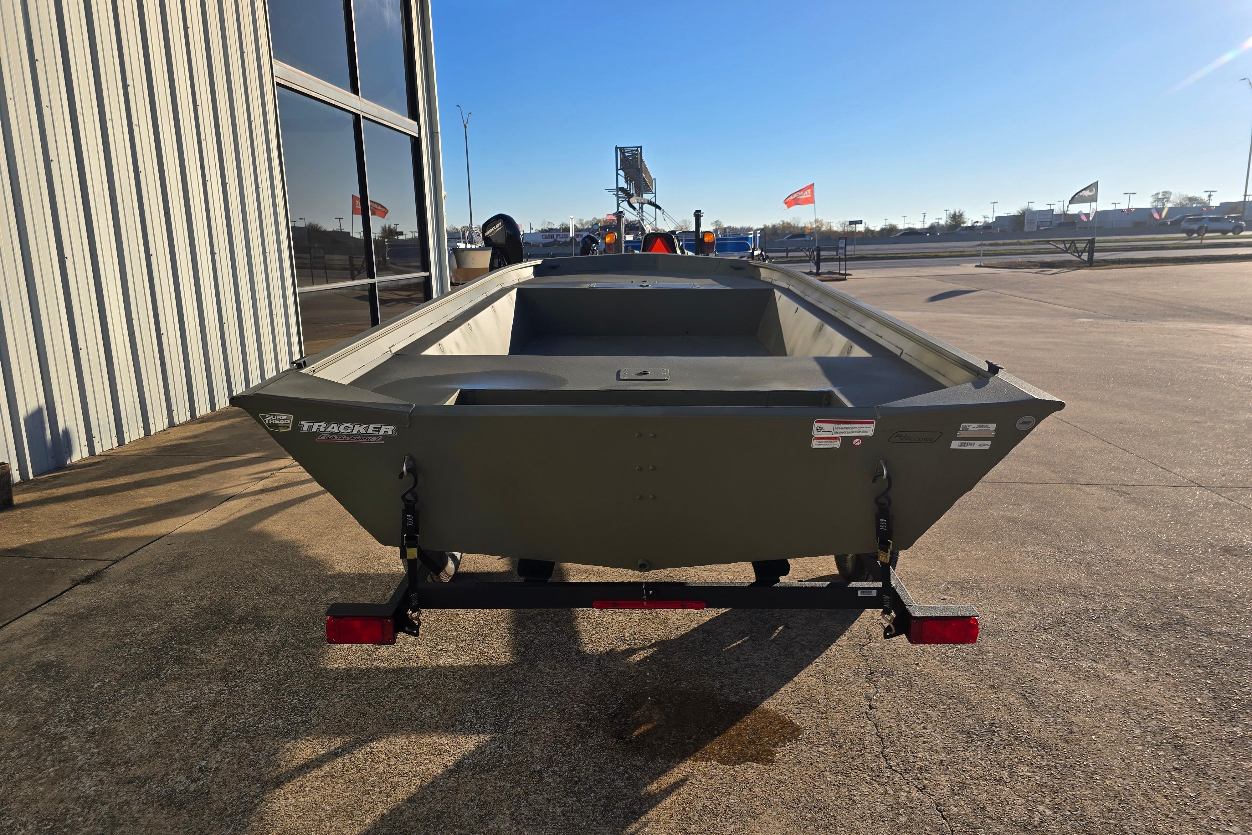 2025 Tracker Grizzly 1860 Utility boat on trailer, parked outdoors.