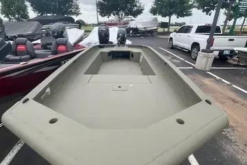 2026 Tracker Grizzly 1650 T Prairie Wings Edition boat in parking lot, surrounded by vehicles.