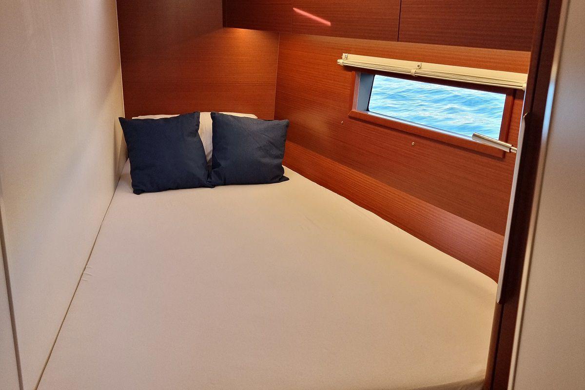 Cozy cabin interior of 2024 Hanse 460 yacht with ocean view window.