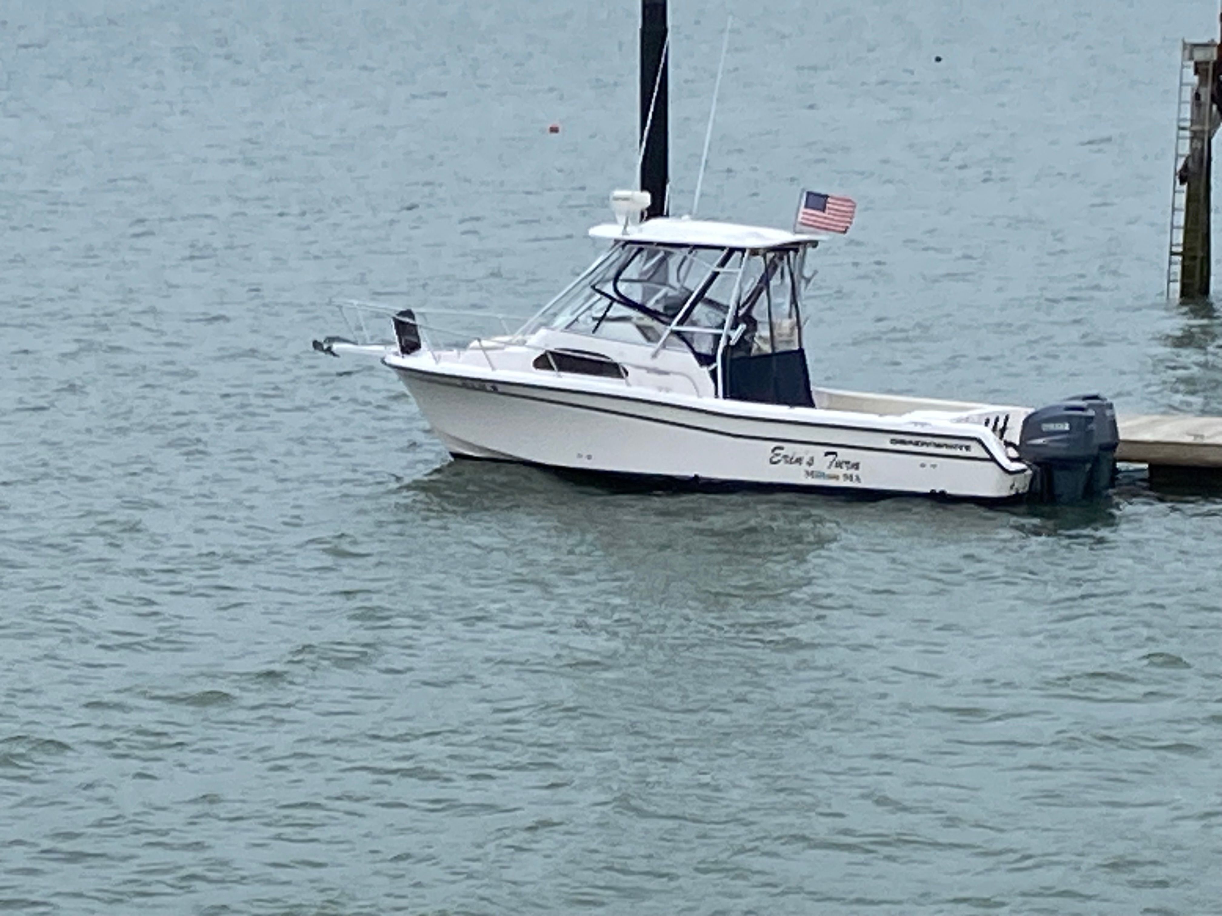 A 2003 Grady-White Sailfish 282 boat docked. It features a cabin and a U.S. flag.