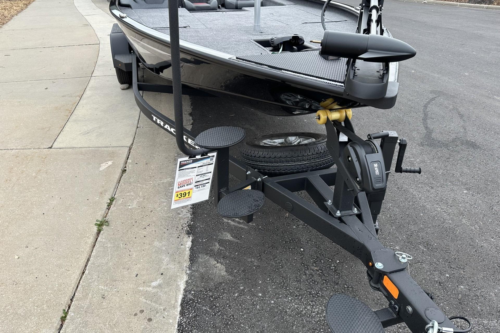 2025 Tracker Savage 215 boat on trailer, parked on street, price tag visible.
