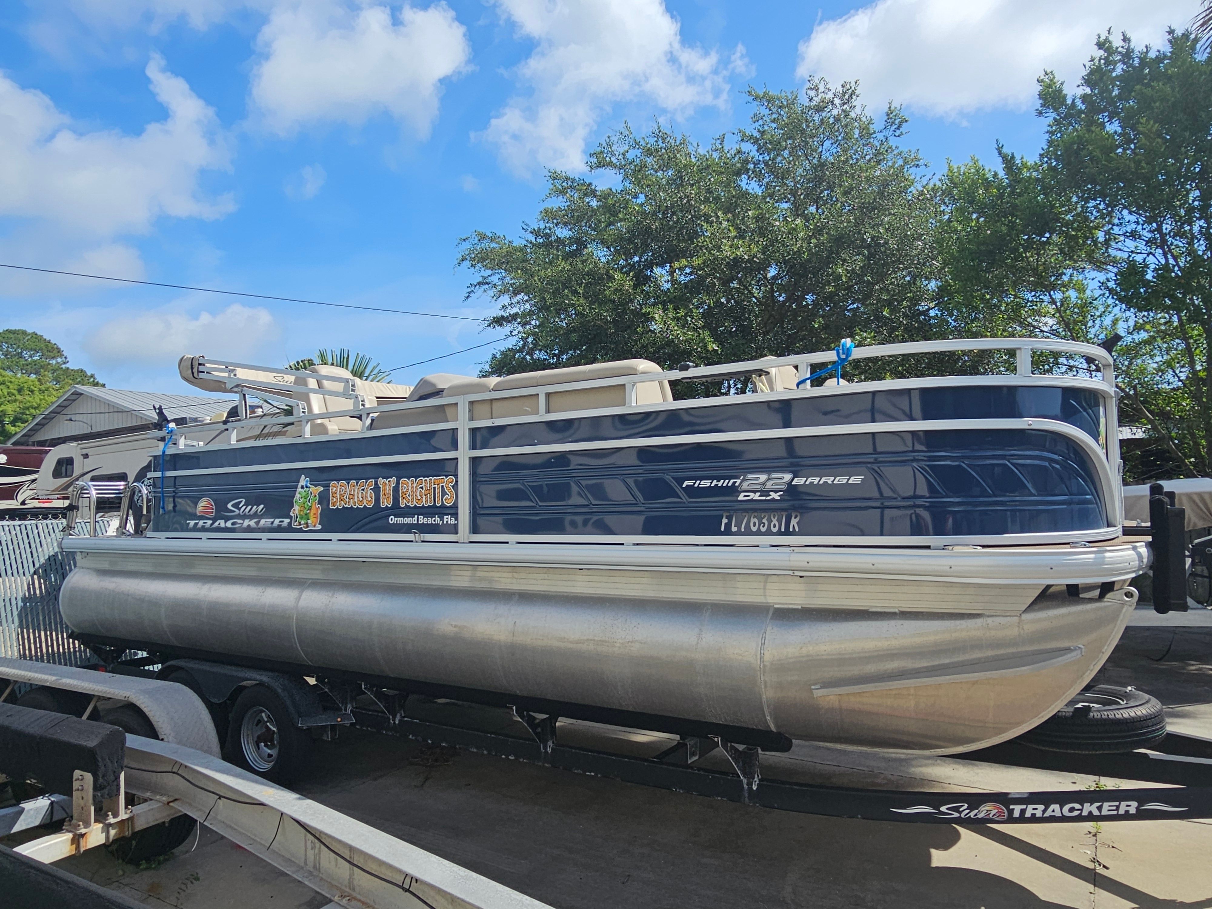 2024 Sun Tracker Fishin' Barge 22 DLX pontoon boat on trailer.