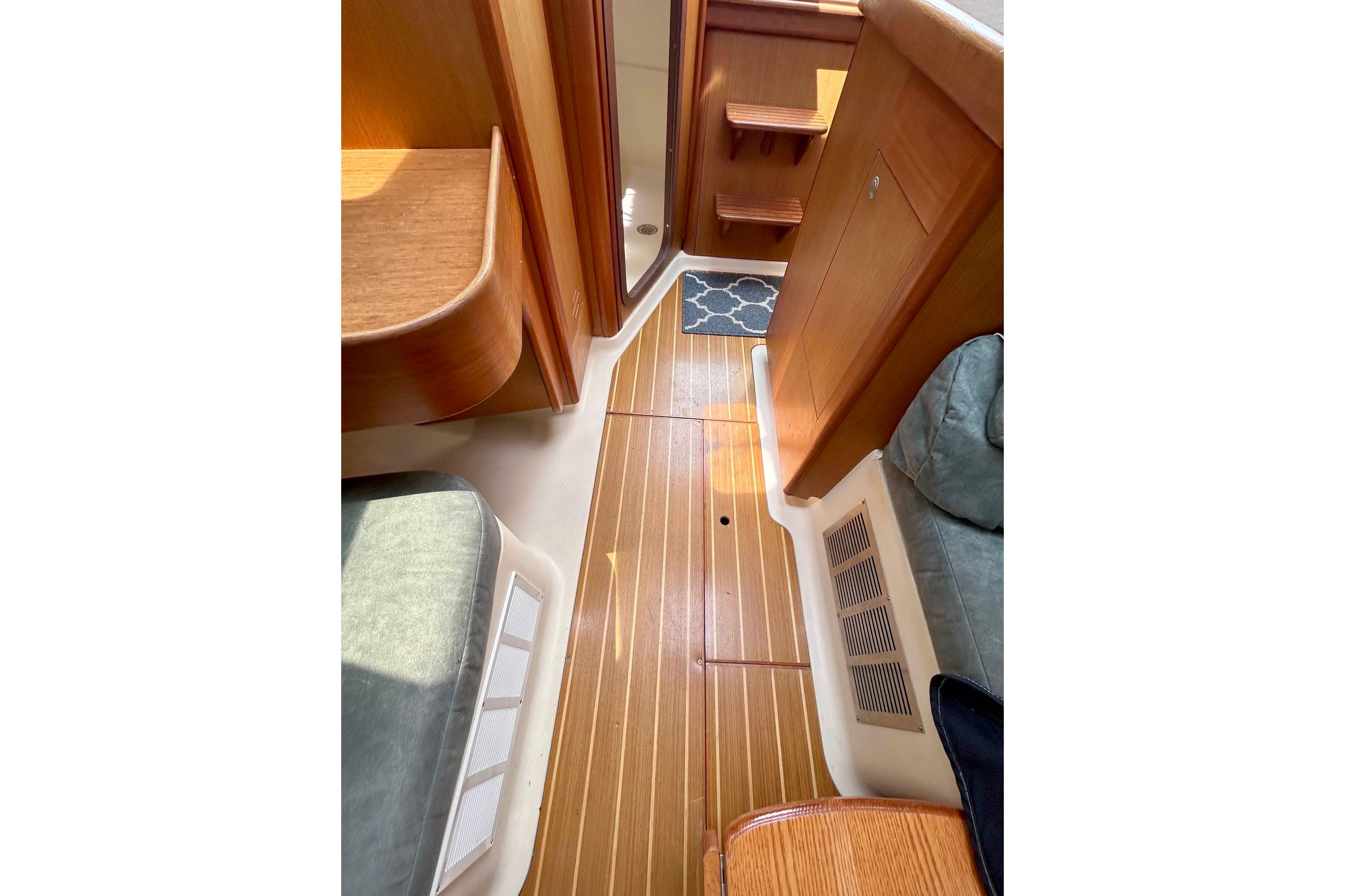 Interior of a 1998 Hunter 340 sailboat with wooden flooring and seating.