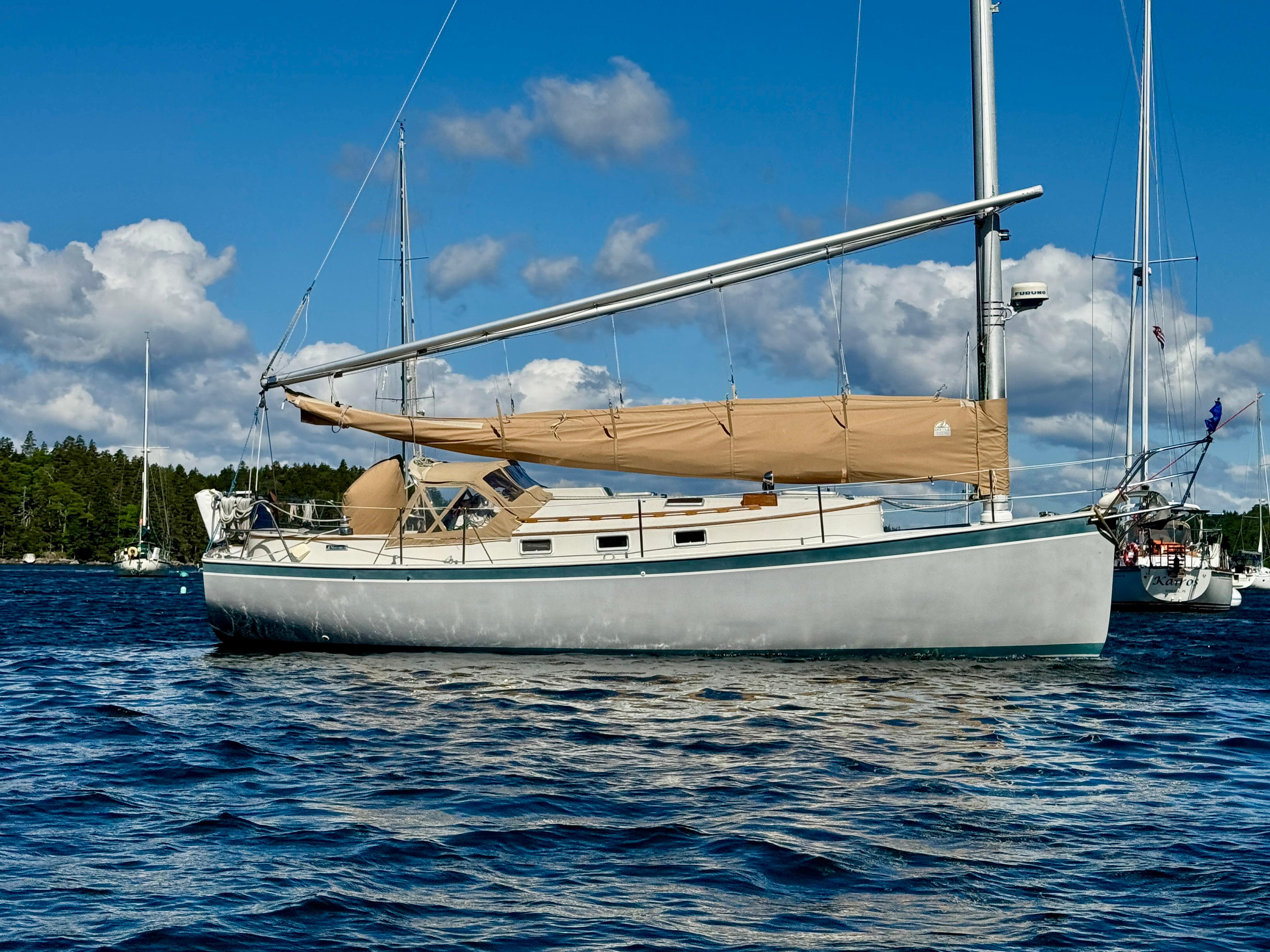 1989 Nonsuch 30 Ultra sailboat on calm water under blue sky.