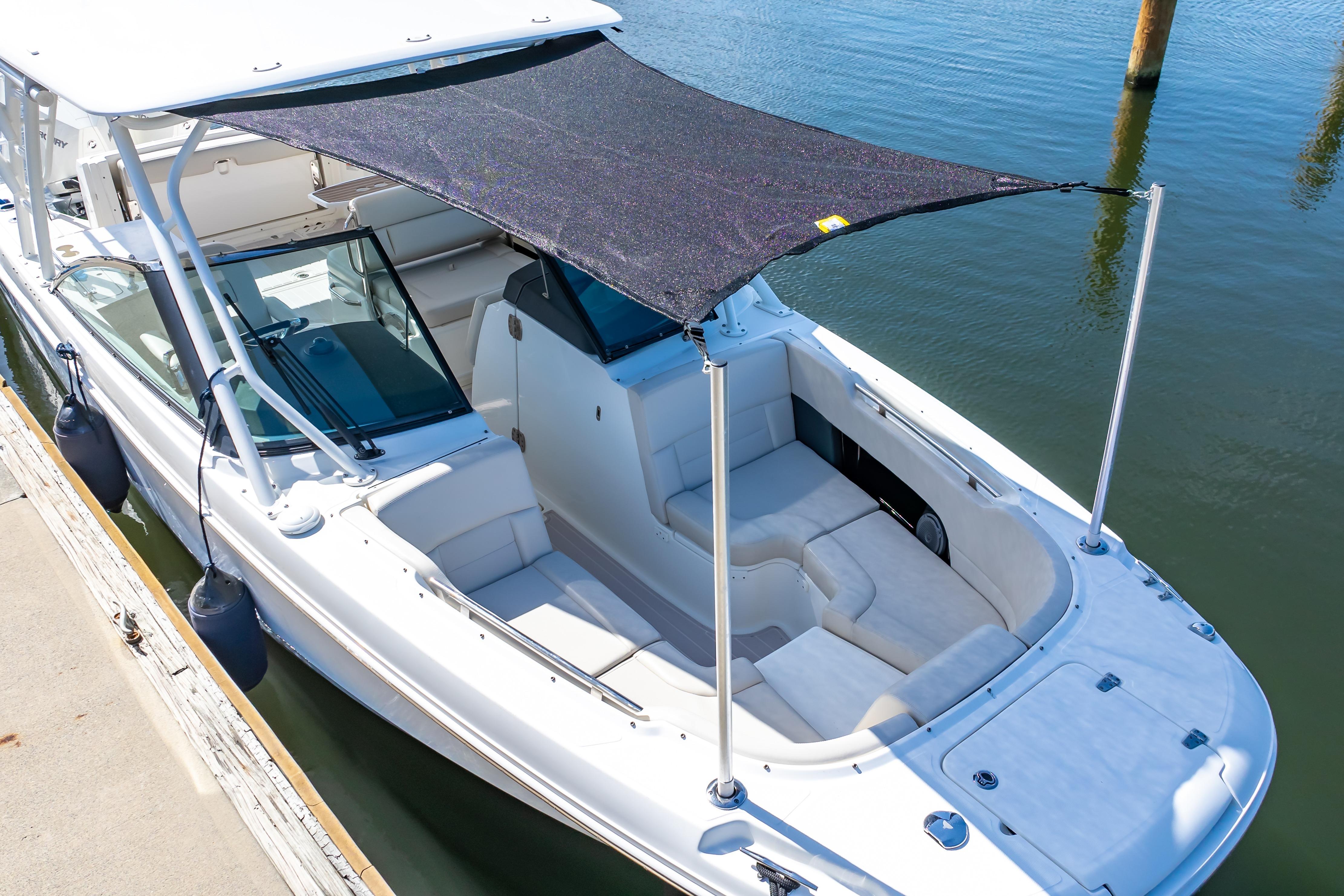 2019 Boston Whaler 270 Vantage boat with sunshade docked at marina.