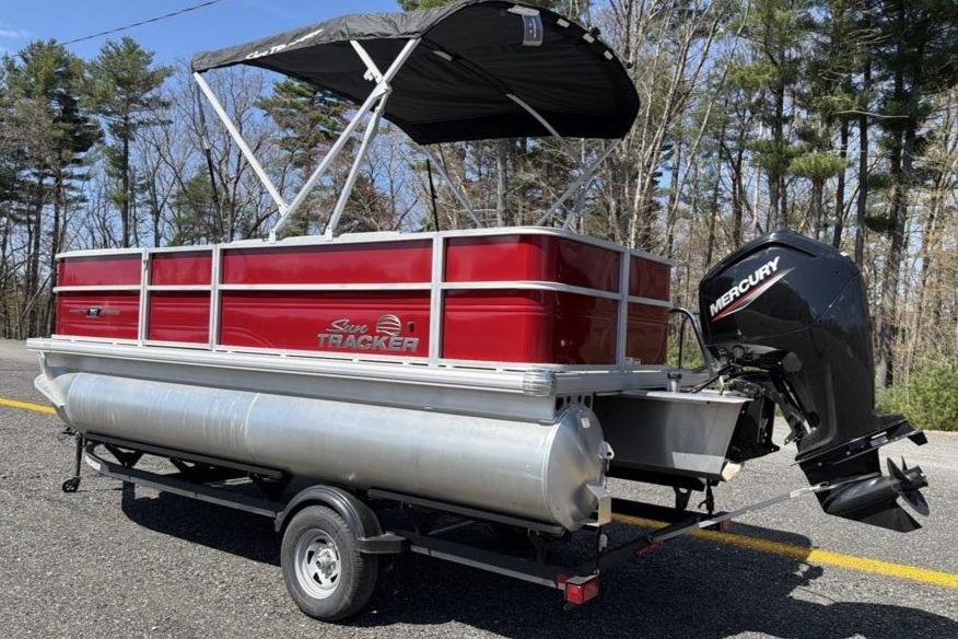 2026 Sun Tracker Party Barge 18 DLX pontoon boat on trailer, with Mercury outboard motor.