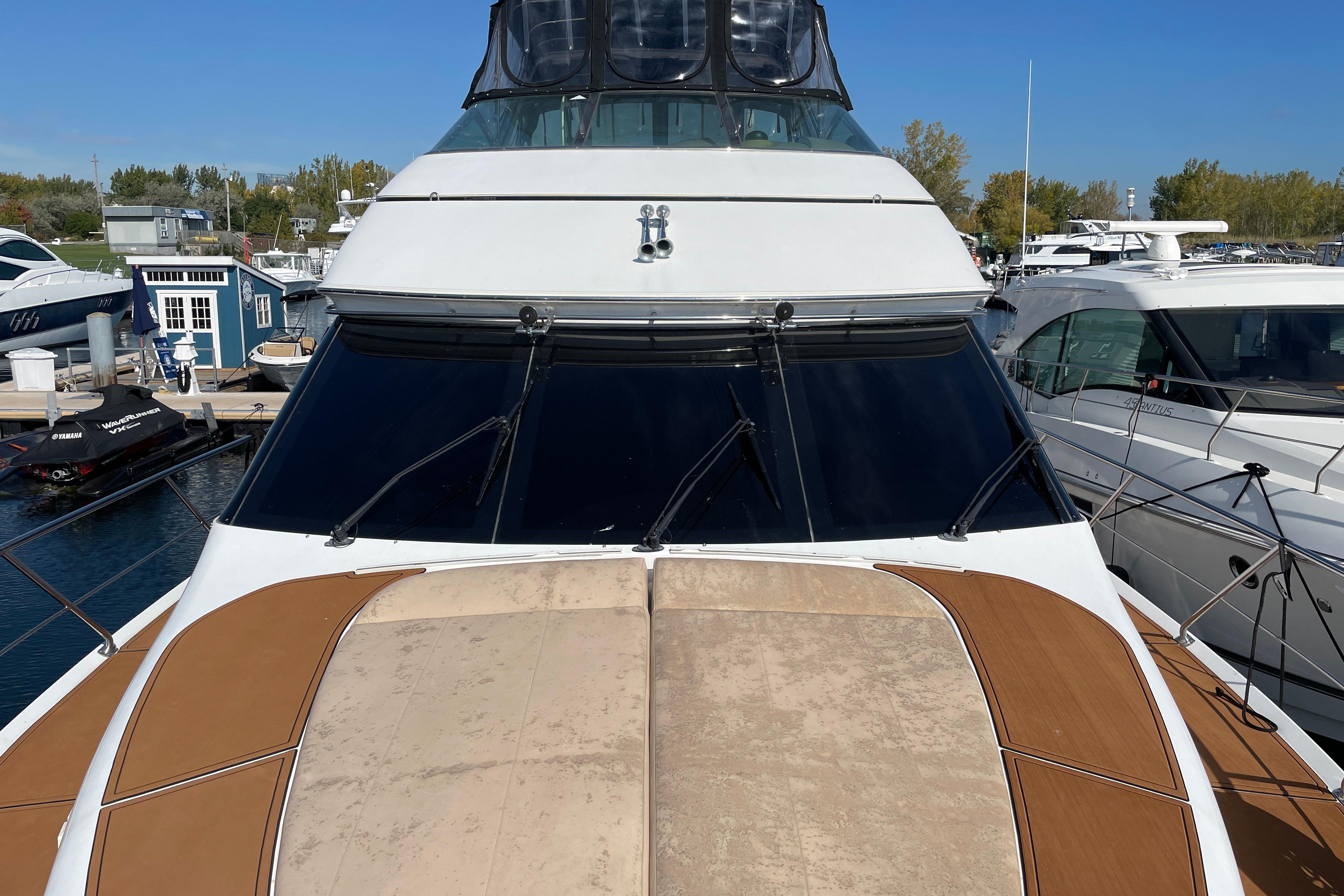 2002 Carver 570 Voyager Pilothouse yacht docked at marina, featuring sleek design and spacious deck.