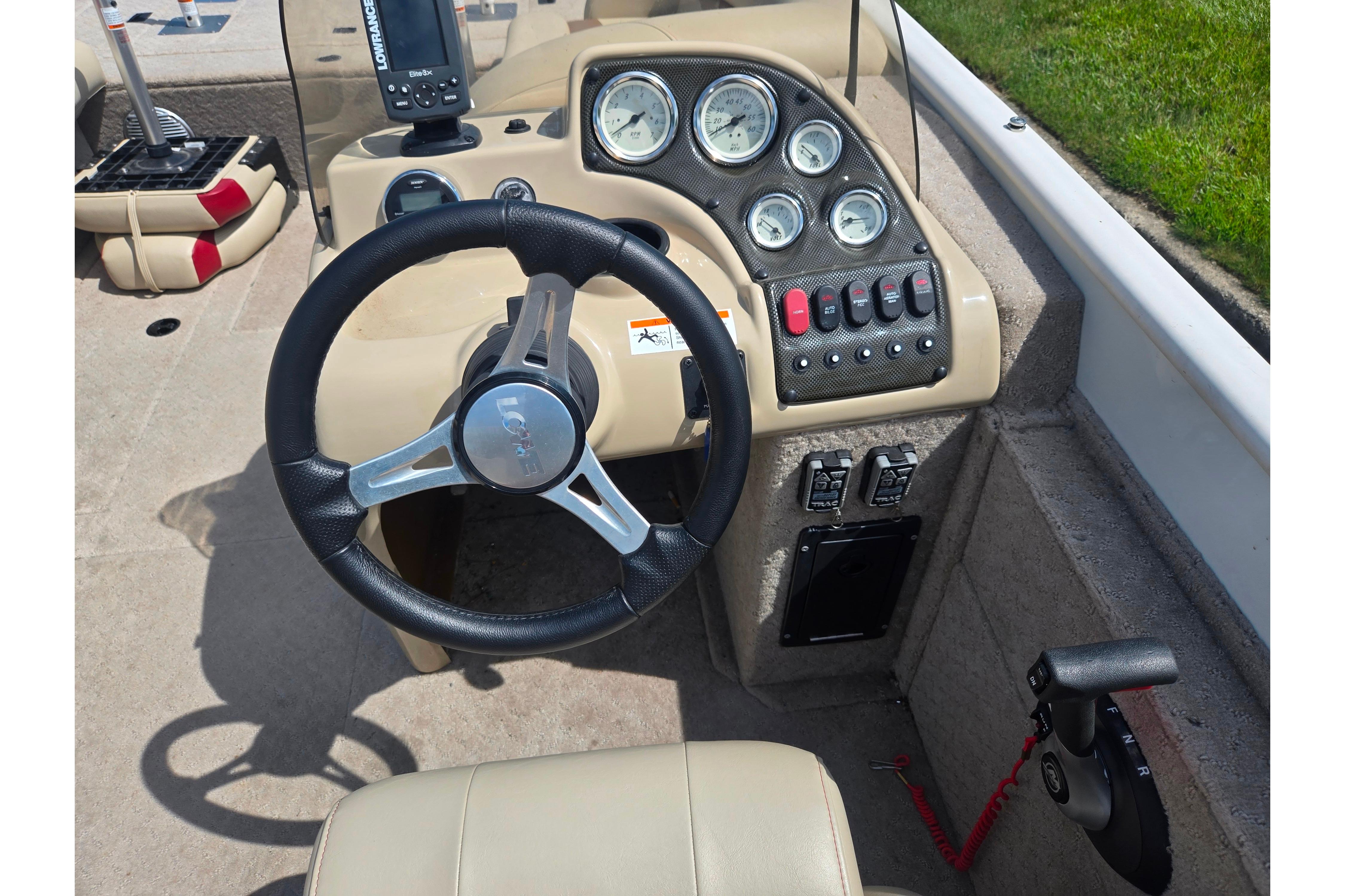 2015 Lowe Sport Deck 224 boat dashboard with steering wheel and control panel.