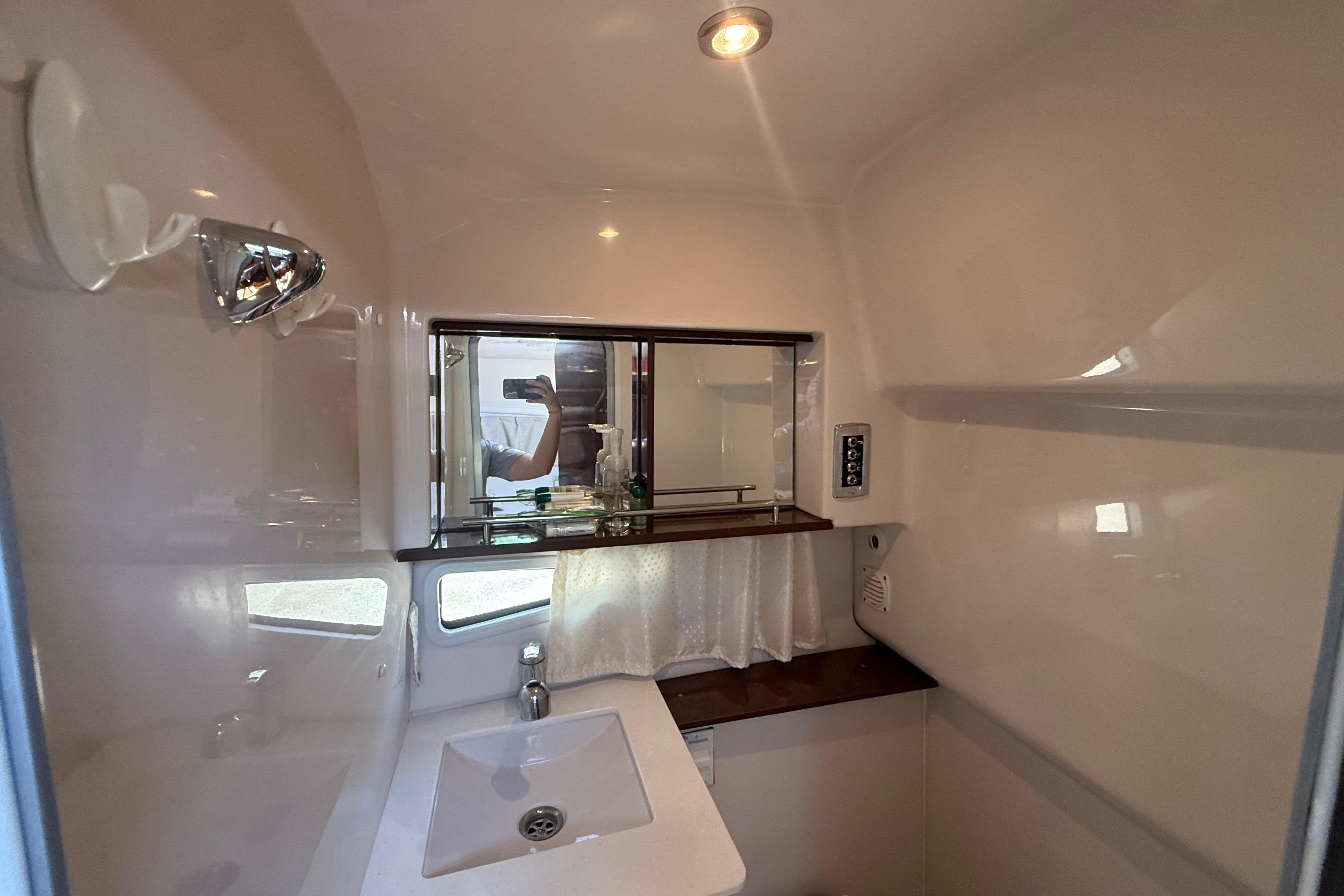2017 Four Winns V275 bathroom interior with sink, mirror, and lighting.