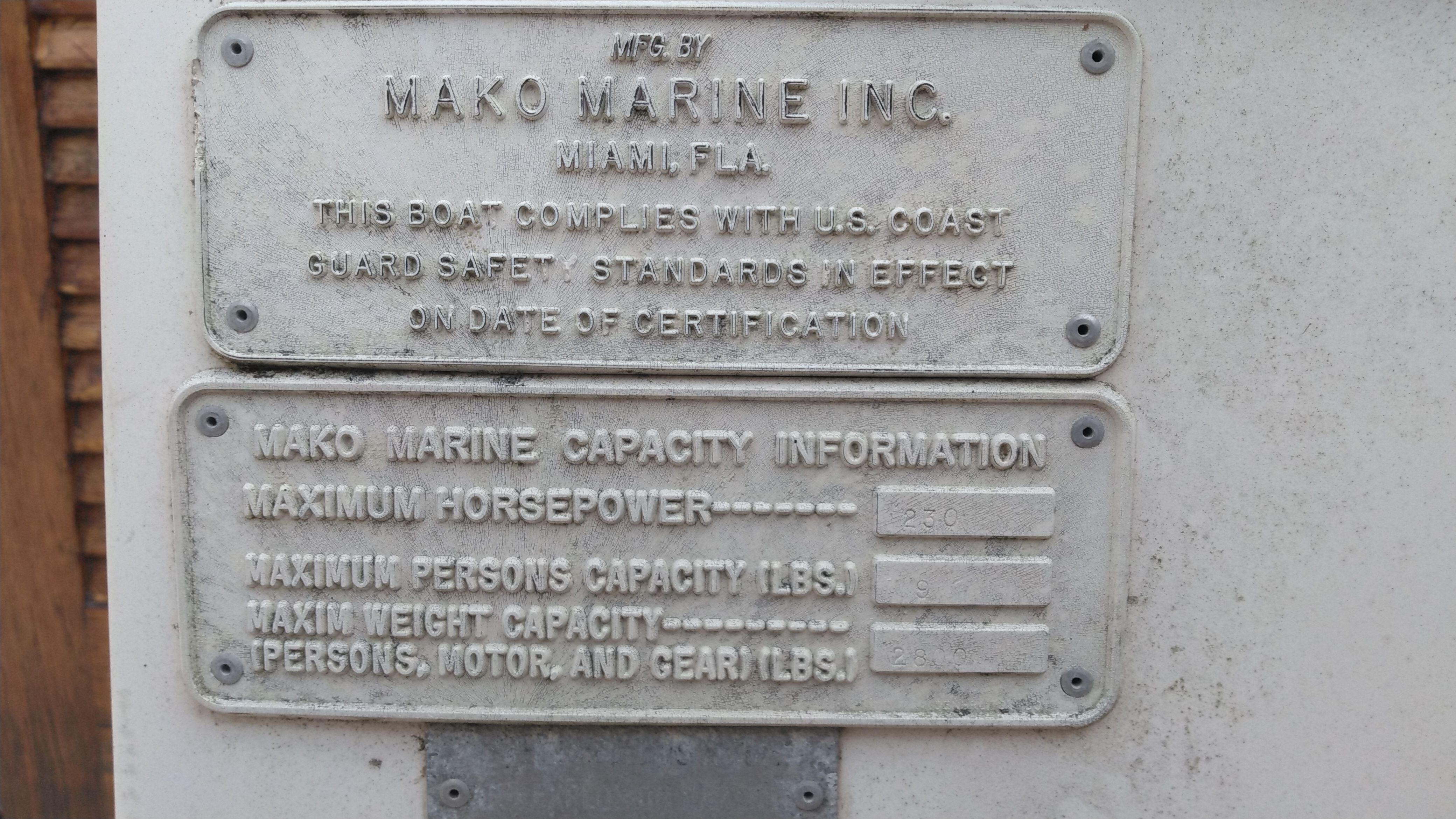 Close-up of boat plaques showing manufacturer and capacity information.