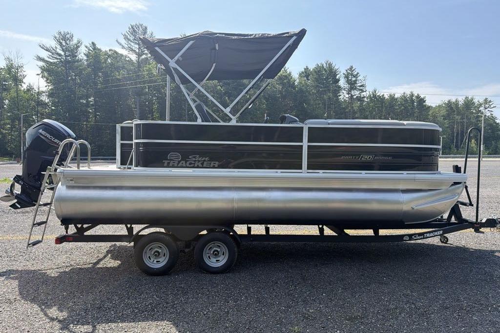 2026 Sun Tracker Party Barge 20 DLX pontoon boat on trailer, parked outdoors.