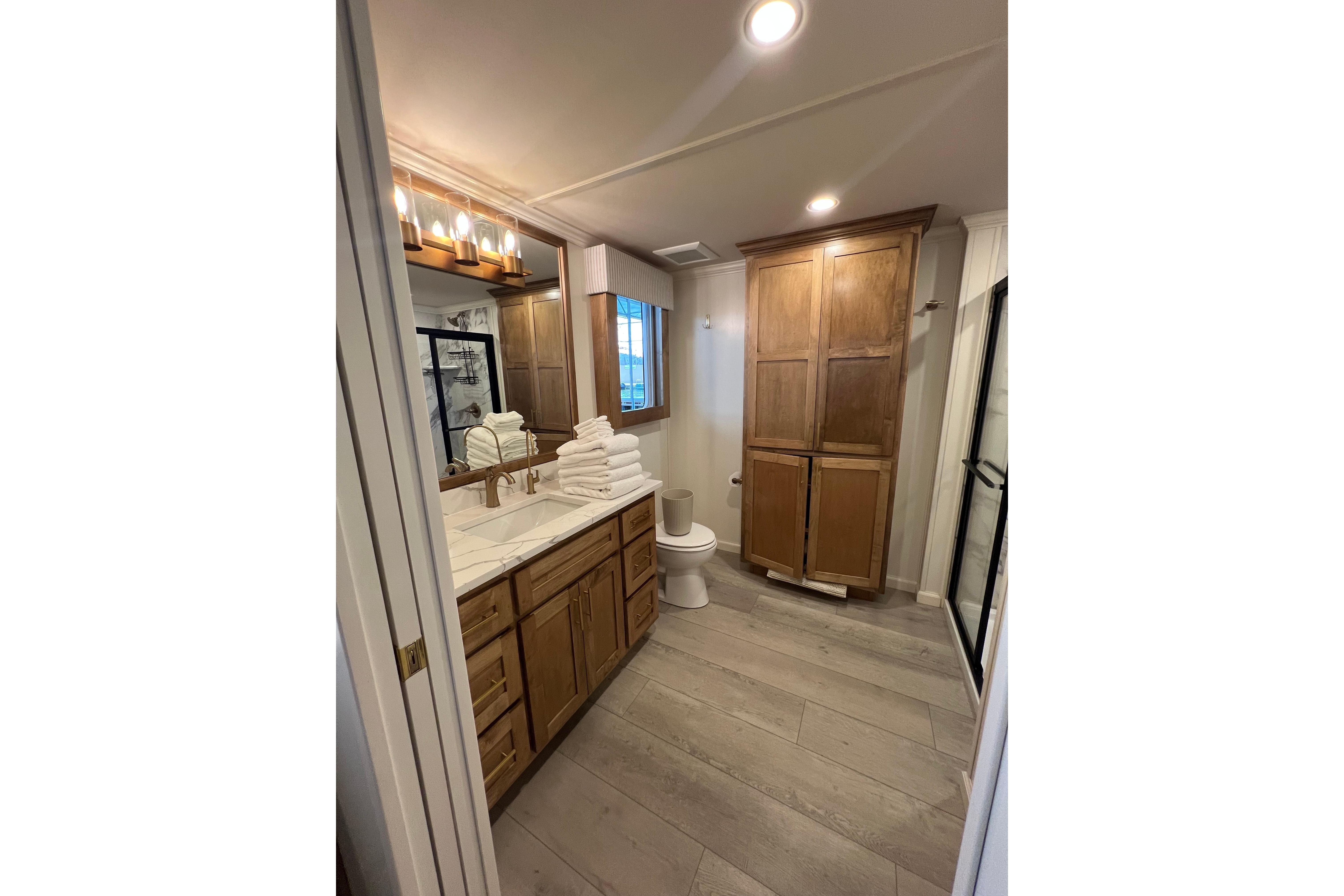 Modern bathroom in 2025 Sumerset Excellence Multiple Shares houseboat, featuring wooden cabinets and elegant lighting.