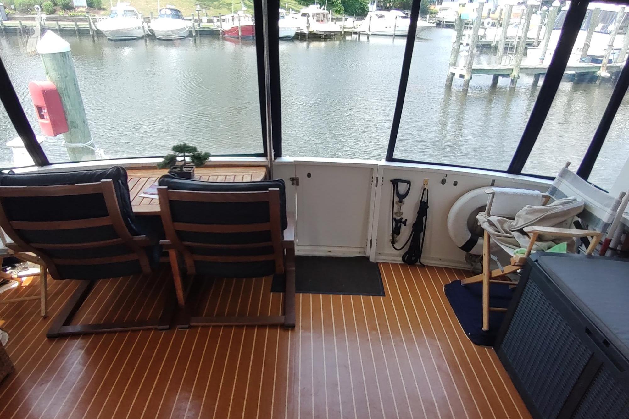 1989 Hyatt Double Cabin Motoryacht interior with seating, table, and marina view.