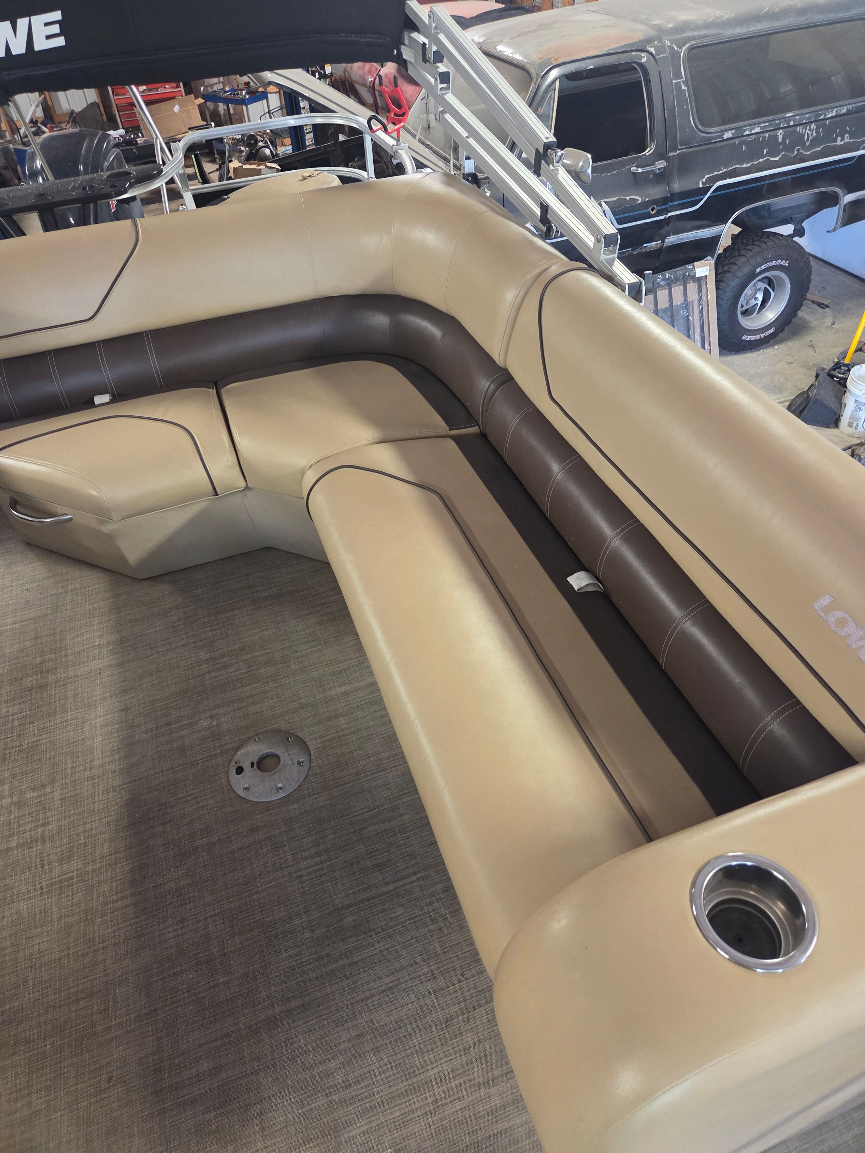 A boat with beige and brown seating in a workshop.