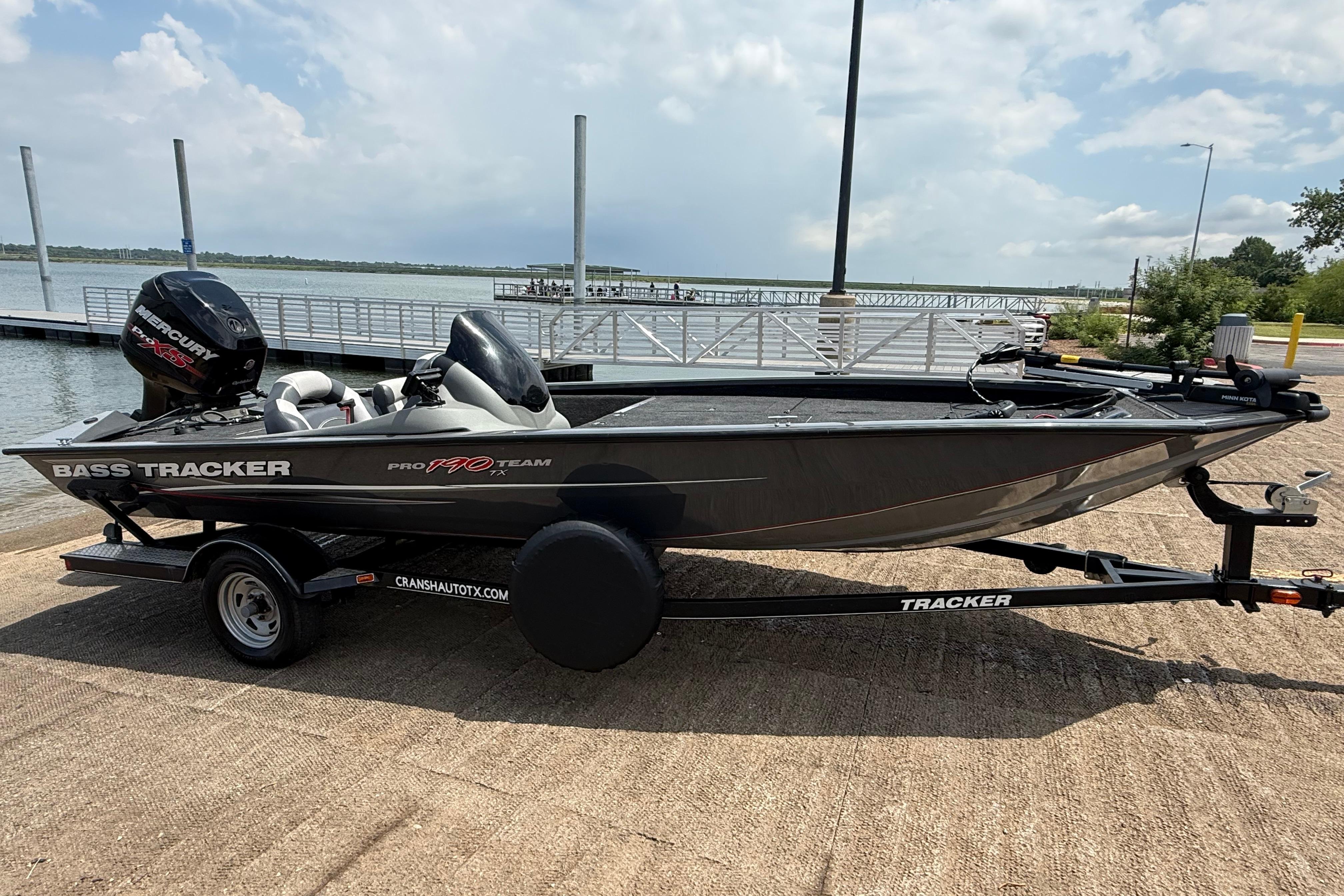 2015 Tracker Pro Team 190 TX bass boat on trailer by a lake.